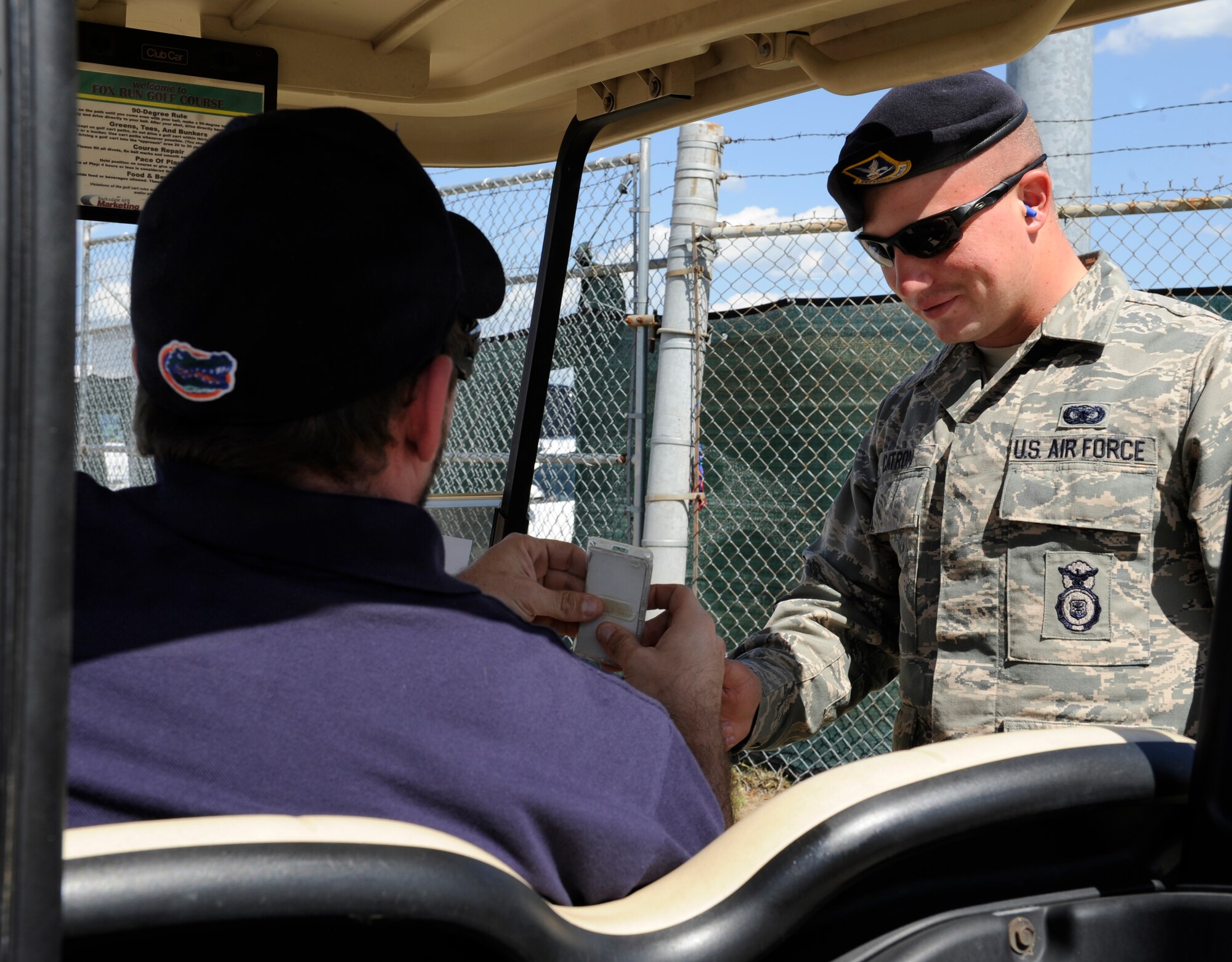 Senior Airman James Catron, 2nd Security Forces Squadron Combat Arms, checks the I.D. of an air show worker at the 2012 Barksdale Air Force Base Defenders of Liberty Air Show April 22. Catron ensured only base personnel, commanders, vendors and distinguished visitors made it through his entrance point. (U.S. Air Force photo/Airman 1st Class Benjamin Gonsier)(RELEASED)
