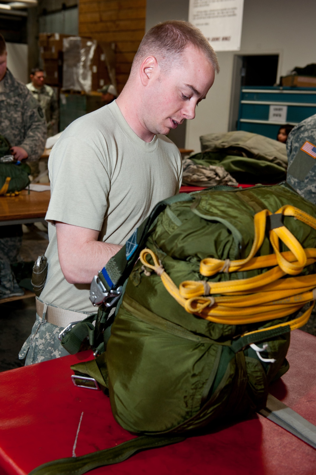 JOINT BASE ELMENDORF-RICHARDSON, Alaska - - Sgt. Evan Mason, parachute packer, 4th Quartermaster Detachment (Airborne), 17th Combat Sustainment Support Battalion, begins the first stage of the inspection process, April 4. Once a parachute is complete, it is handed to the first inspector who gives the ???rigger roll??? a good look over to make sure it is correct. The parachute then goes to the final inspector. (U.S. Air Force photo/Johnathon Green)
