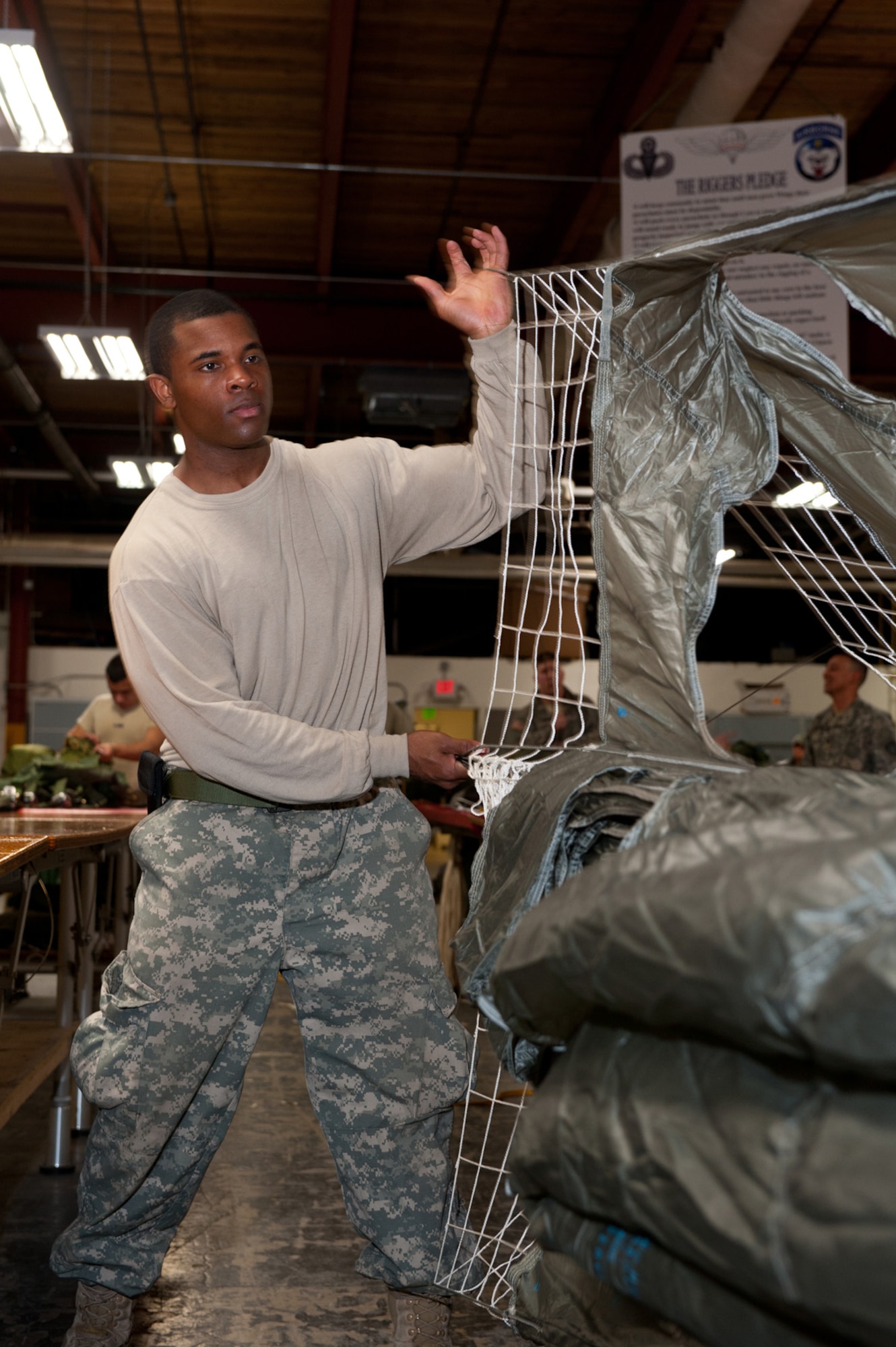 JOINT BASE ELMENDORF-RICHARDSON, Alaska - - Sgt. Rasheen Threatts, parachute inspector, 4th Quartermaster Detachment (Airborne), 17th Combat Sustainment Support Battalion, begins the process of folding a parachute, April 4. This particular portion of folding is called, "folding the gores." (U.S. Air Force photo/Johnathon Green)