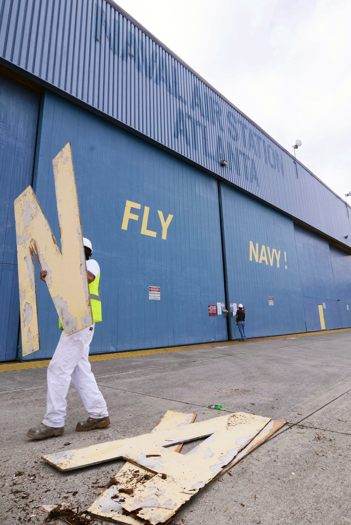 A worker takes away the letters from the signage displayed on Hangar 5 after being removed from one of the last structures still holding the identity of the former Naval Air Station Atlanta April 17. (U.S. Air Force photo/Don Peek)