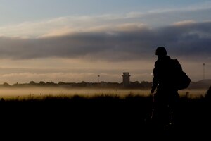 A raptor town Airmen walks to the bus stop after a shift change during exercise Coronet White at the Raptor Town entry control point at Langley Air Force Base, Va., April 20. The Phase I and Phase II exercise was held to validate the full spectrum of Langley's deployment operations. (U.S. Air Force photo by Senior Airman John D. Strong II/Released)