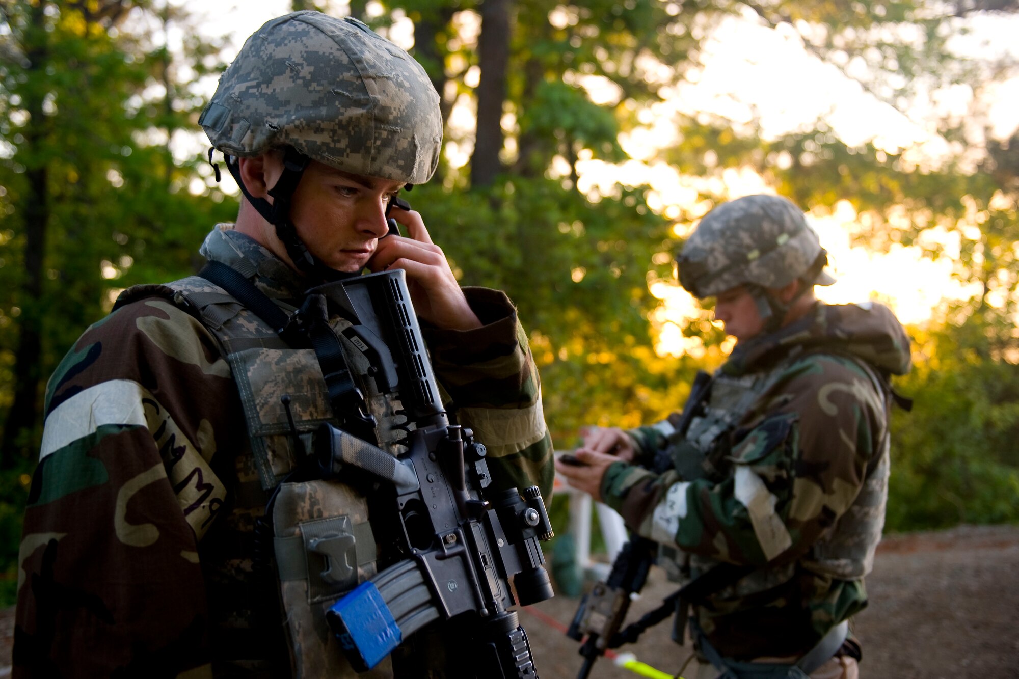 Airman 1st Class Kyle Dehaan and Jordan Jensen 633rd Security Forces Squadron entry control point guards, listen to an incoming radio message and take notes during Coronet White at the Raptor Town at Langley Air Force Base, Va., April 20. The Operational Readiness Exercise was held to help Langley Airmen to prepare for the upcoming Operational Readiness Inspection. (U.S. Air Force photo by Senior Airman John D. Strong II/Released)