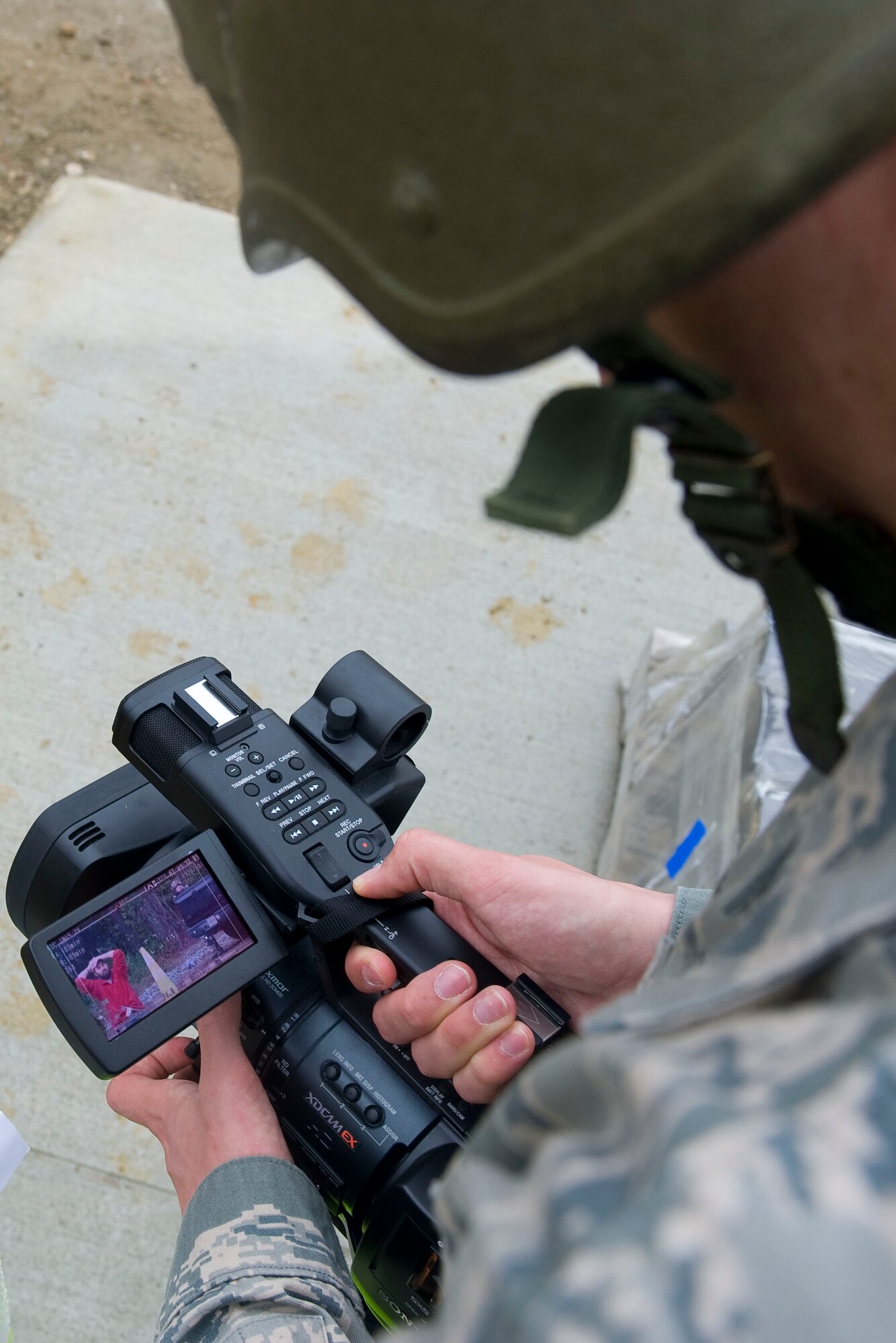 Airman 1st Class Anthony Hetlage, 633rd Air Base Wing Public Affairs broadcaster, records the apprehension of an intruder during exercise Coronet White in Raptor Town at Langley Air Force Base, Va., April 19. The Phase I and Phase II exercise was held to validate the full spectrum of Langley's deployment operations. (U.S. Air Force photo by Senior Airman John D. Strong II/Released)