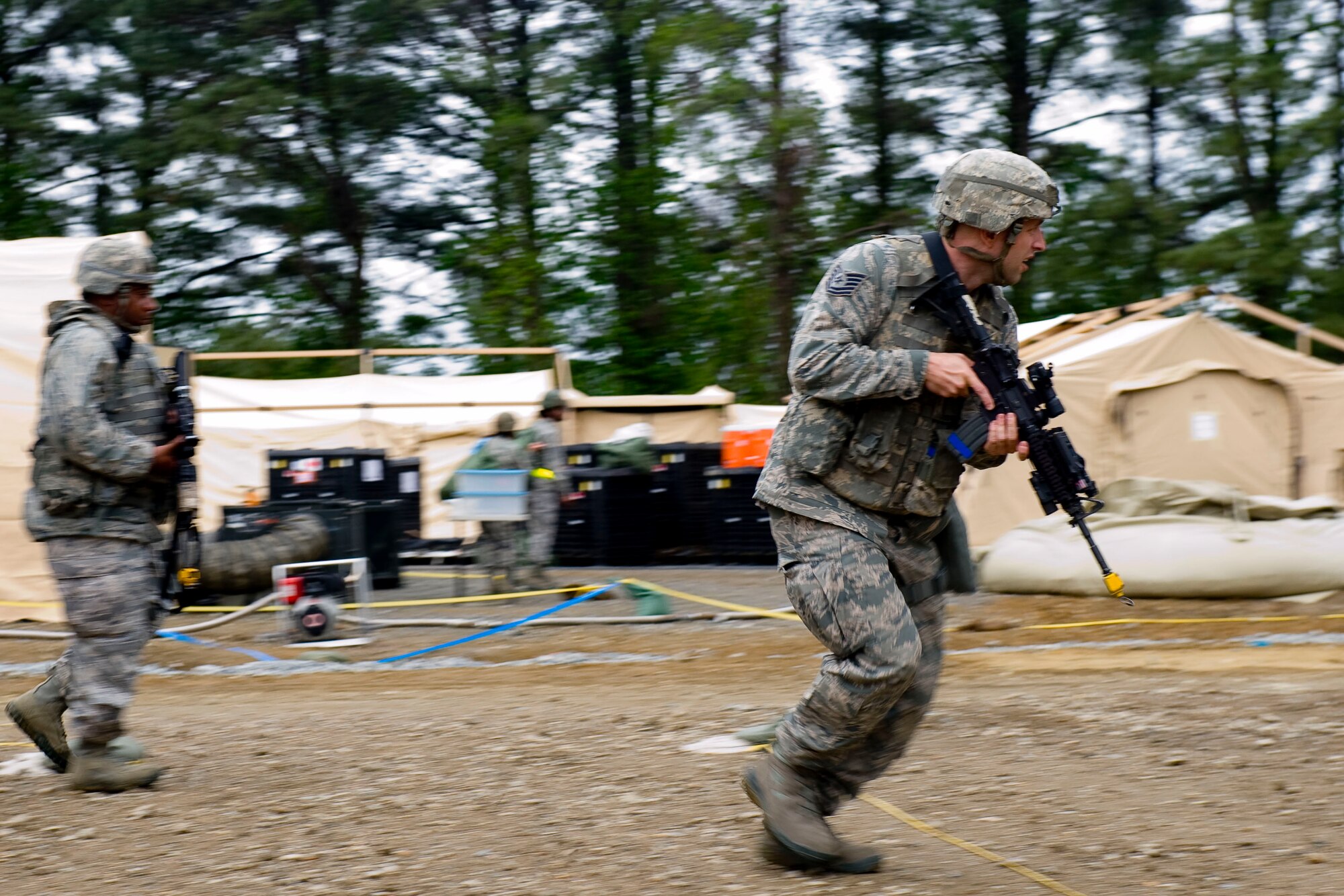 Tech. Sgt. Brandon Binczac, 633rd Security Forces Squadron Combat Arms instructor, sprints in response to an intruder alert during exercise Coronet White in Raptor Town at Langley Air Force Base, Va., April 19. The Phase I and Phase II exercise was held to validate the full spectrum of Langley's deployment operations. (U.S. Air Force photo by Senior Airman John D. Strong II/Released)