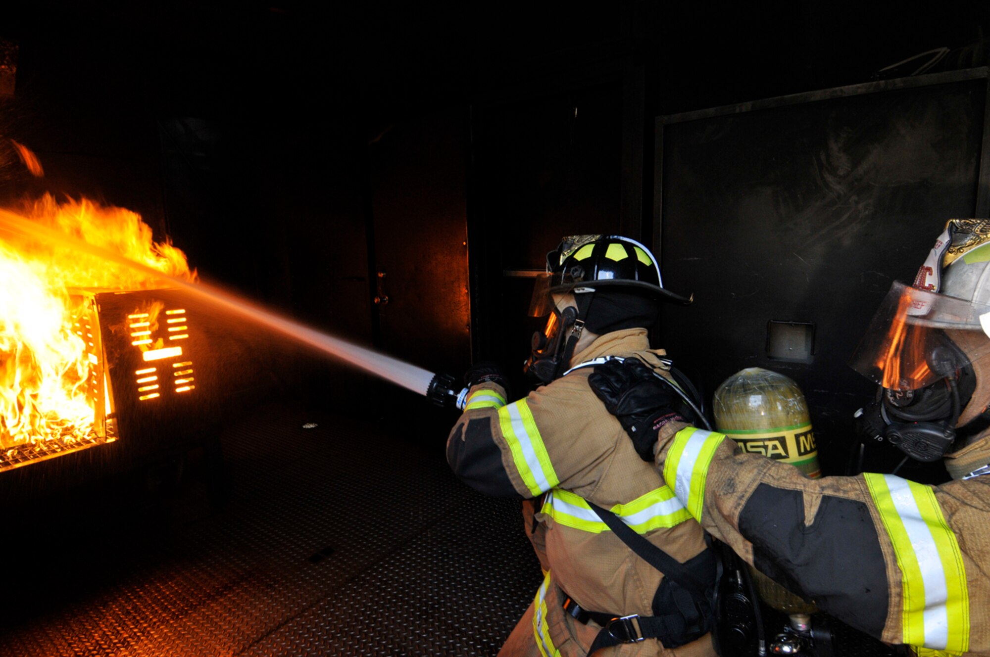 AEDC firefighters extinguish a fire in West Virginia University Fire Service Extension’s training unit March 27. The fires in the trailer are fueled by propane. (Photo by Rick Goodfriend)