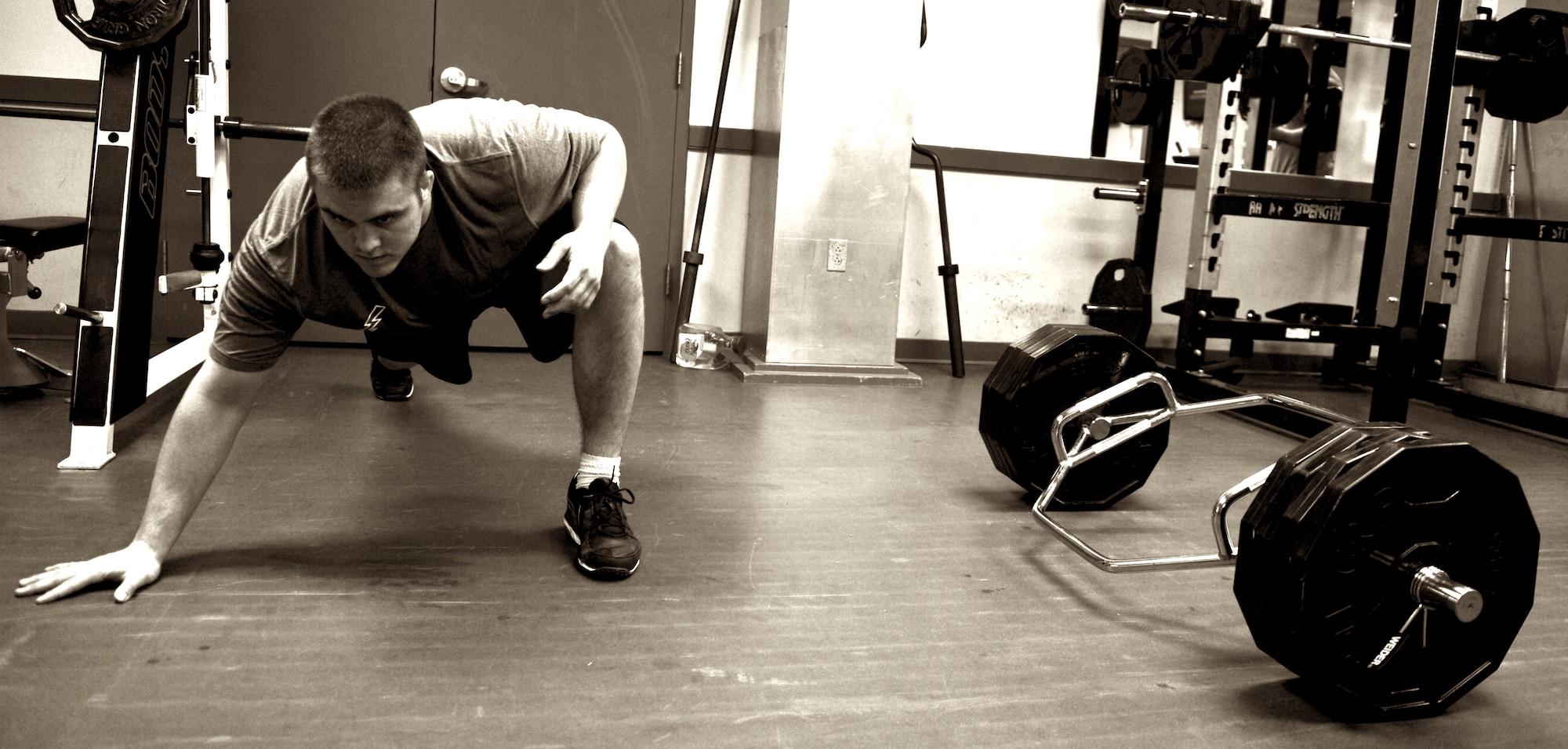 Second Lt. Ben Garland, 375th Air Mobility Wing Public Affairs chief of media operations, stretches between sets of squats in the James Gym weight room March 12, 2012 at Scott Air Force Base, Ill. He uses stretching during lifting for active recovery. By stretching in between sets he can get the maximum tear in his muscles that will help with getting stronger faster. (U.S. Air Force photo/ Staff Sgt. Brian J. Valencia)