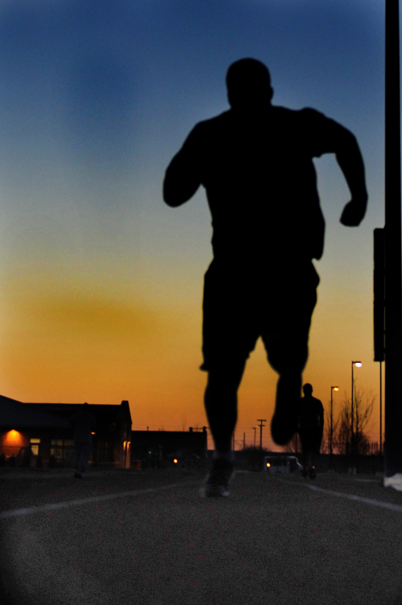 Second Lt. Ben Garland, 375th Air Mobility Wing Public Affairs chief of media operations, runs sprints at the James Gym track as the sun goes down March 12, 2012 on Scott Air Force Base, Ill. Garland worked out 5 hours a day to stay competitive for his shot with the Denver Broncos. He combined stretching and mobility exercises with strength conditioning, weightlifting and speed work each day. (U.S. Air Force photo/Staff Sgt. Brian J. Valencia)