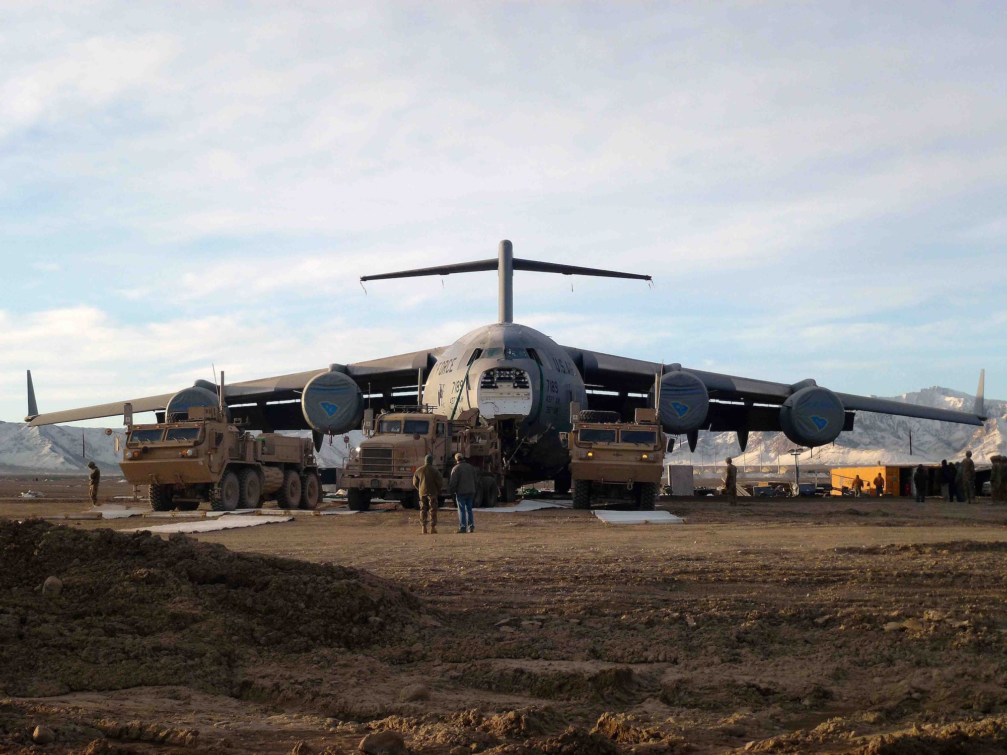 Army vehicles begin their efforts to recover a C-17 Globemaster III after it slid off the runway in Logan Province, Afghanistan. Air Force engineers worked with the Army and civilian engineers for the recover efforts. (U.S. Army photo)