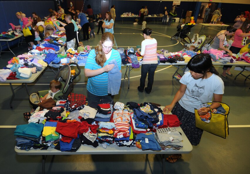 Service members and dependents browse through piles of clothes during a children’s clothes swap April 21 at Schriever Air Force Base fitness center. Leftover clothes will be donated to the Airman’s Attic at Peterson Air Force Base and other local community assistance agencies. (U.S. Air Force photo/Staff Sgt. Julius Delos Reyes)
