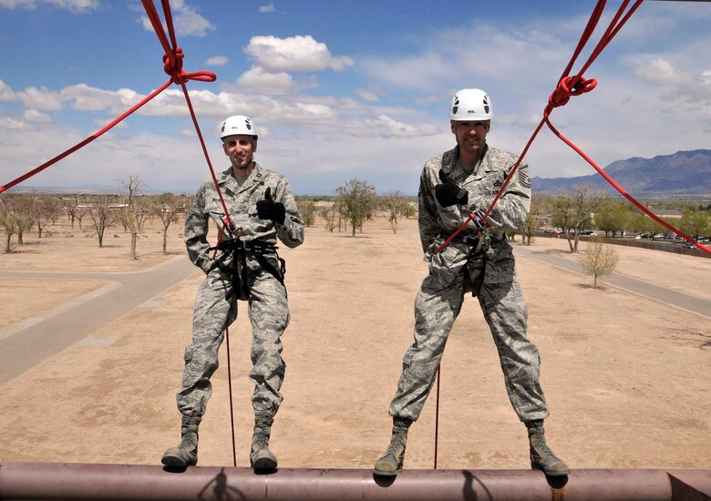 Capt. Heath Wilson, left, and his brother, Master Sgt. Curtis Wilson, prepare to rappel from a wall at the U.S. Air Force Pararescue School at Kirtland Air Force Base, N.M., in April 2012 so that Captain Wilson can administer the oath of reenlistment to Sergeant Wilson. Captain Wilson is assigned to the 99th Medical Group at Nellis AFB, Nev., and Sergeant Wilson is assigned to Air Force Operational Test and Evaluation Center Headquarters at Kirtland. (Photo by George Diamond).