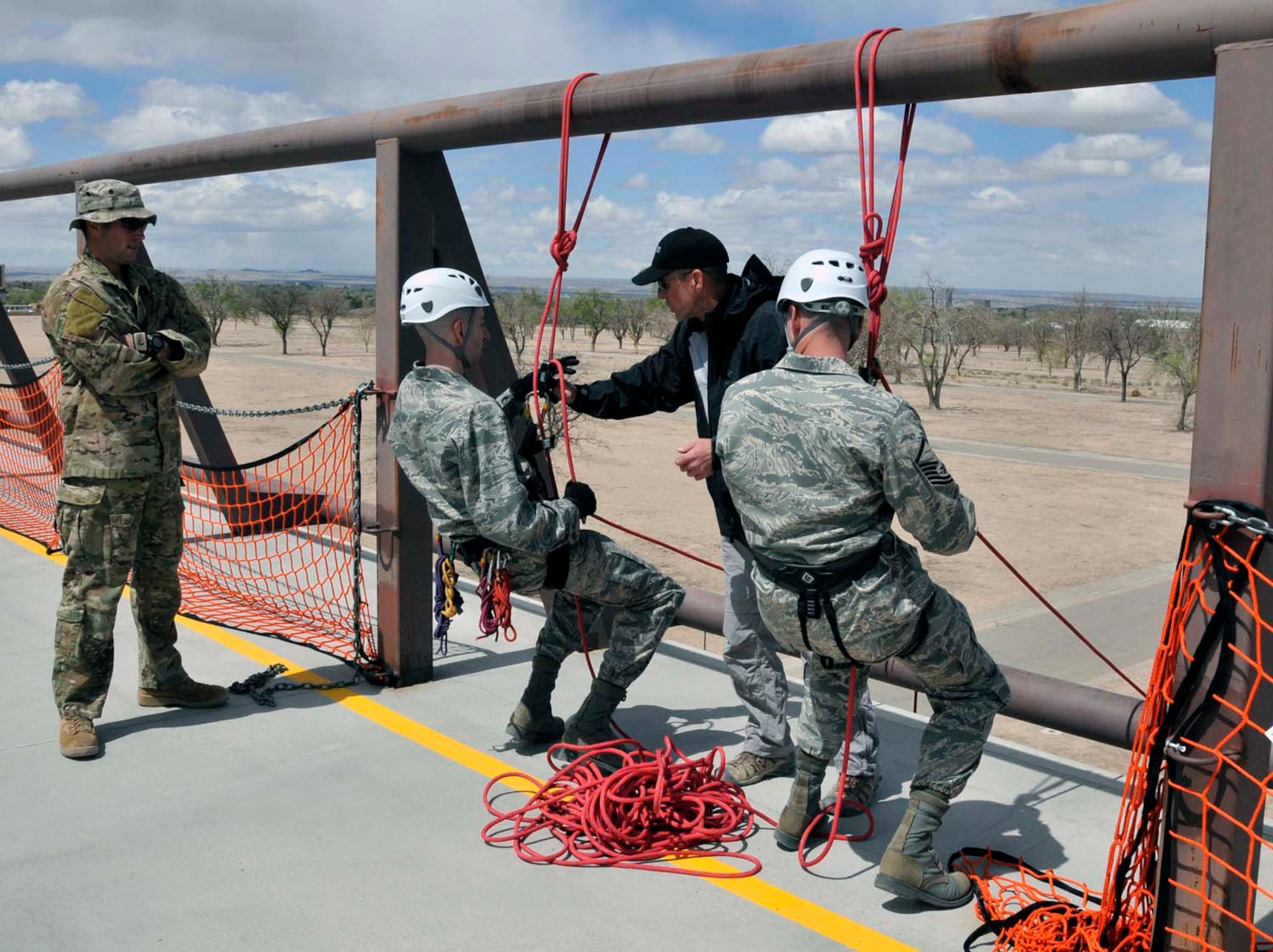 Master Sgt. Curtis Wilson, right, watches as his brother, Capt. Heath Wilson, listens to instructions from U.S. Air Force Pararescue School instructors at Kirtland Air Force Base, N.M., about how to rappel from a wall in preparation for Sergeant Wilson's reenlistment ceremony in April 2012. Sergeant Wilson is assigned to Air Force Operational Test and Evaluation Center Headquarters at Kirtland and Captain Wilson is stationed at Nellis AFB, Nev. (Photo by George Diamond).