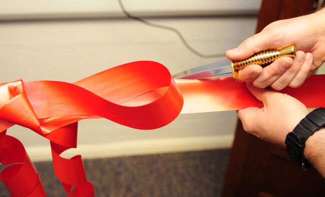 RAF MILDENHALL, England – Col. Gary McCollum, 352nd Special Operations Group commander, prepares to cut the ribbon, opening the new 352nd SOG Heritage Library April 17, 2012. The commander, along with Chief Master Sgt. Paul Henderson, 352nd SOG command chief, and Patrick Charles, 352nd SOG historian, opened the library for their Air Commandos. The library provides a wide range of reading materials, both in book and digital format. (U.S. Air Force photo/Karen Abeyasekere)
