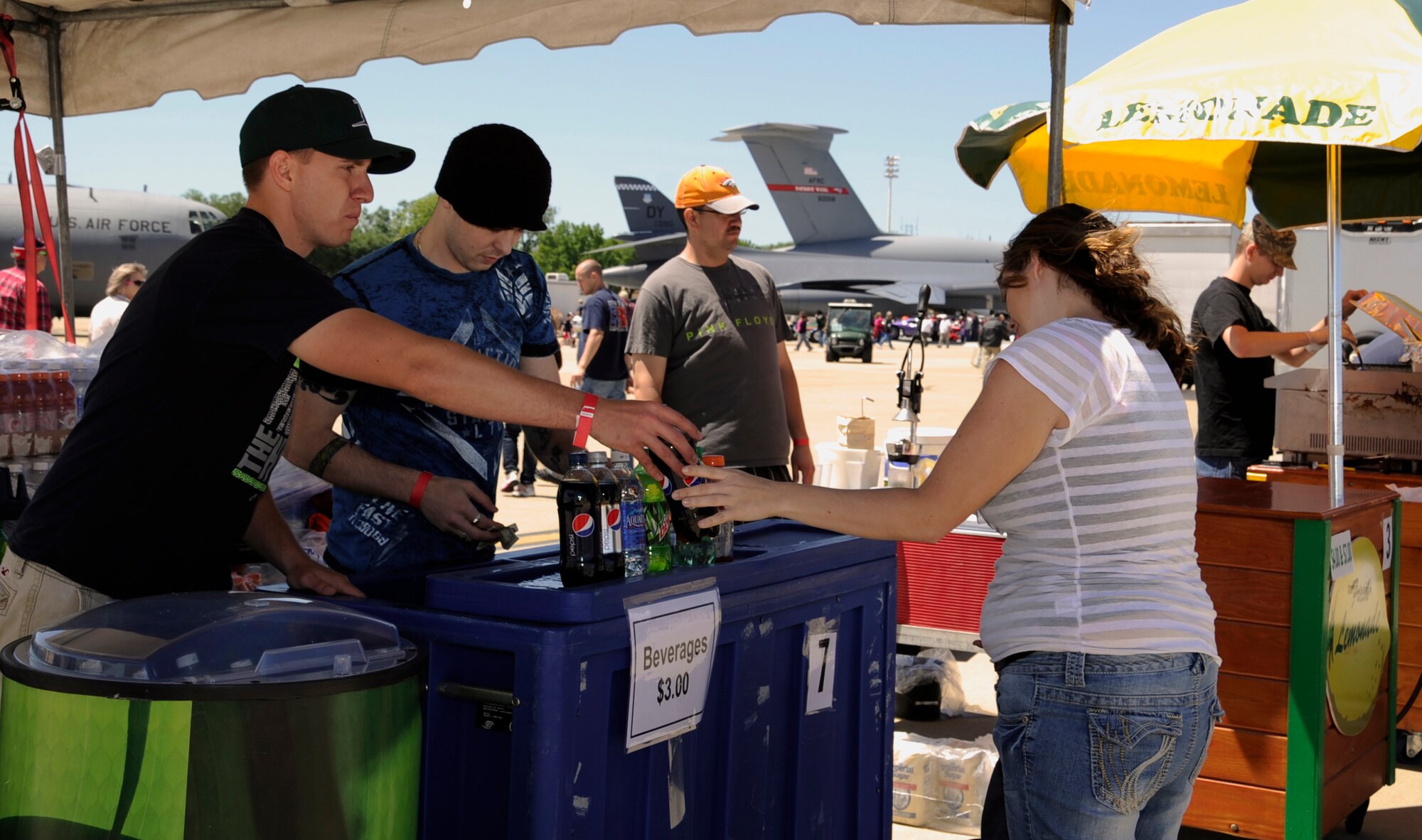 Senior Airman James Lawson, 20th Aircraft Maintenance unit, passes a beverage to a customer at the 2012 Barksdale Air Force Base Defenders of Liberty Air Show April 21. Lawson volunteered to help run a beverage stand with other Barksdale Airmen. A portion of the funds raised will help fund morale activities for base units. (U.S. Air Force photo/Airman 1st Class Benjamin Gonsier)(RELEASED)