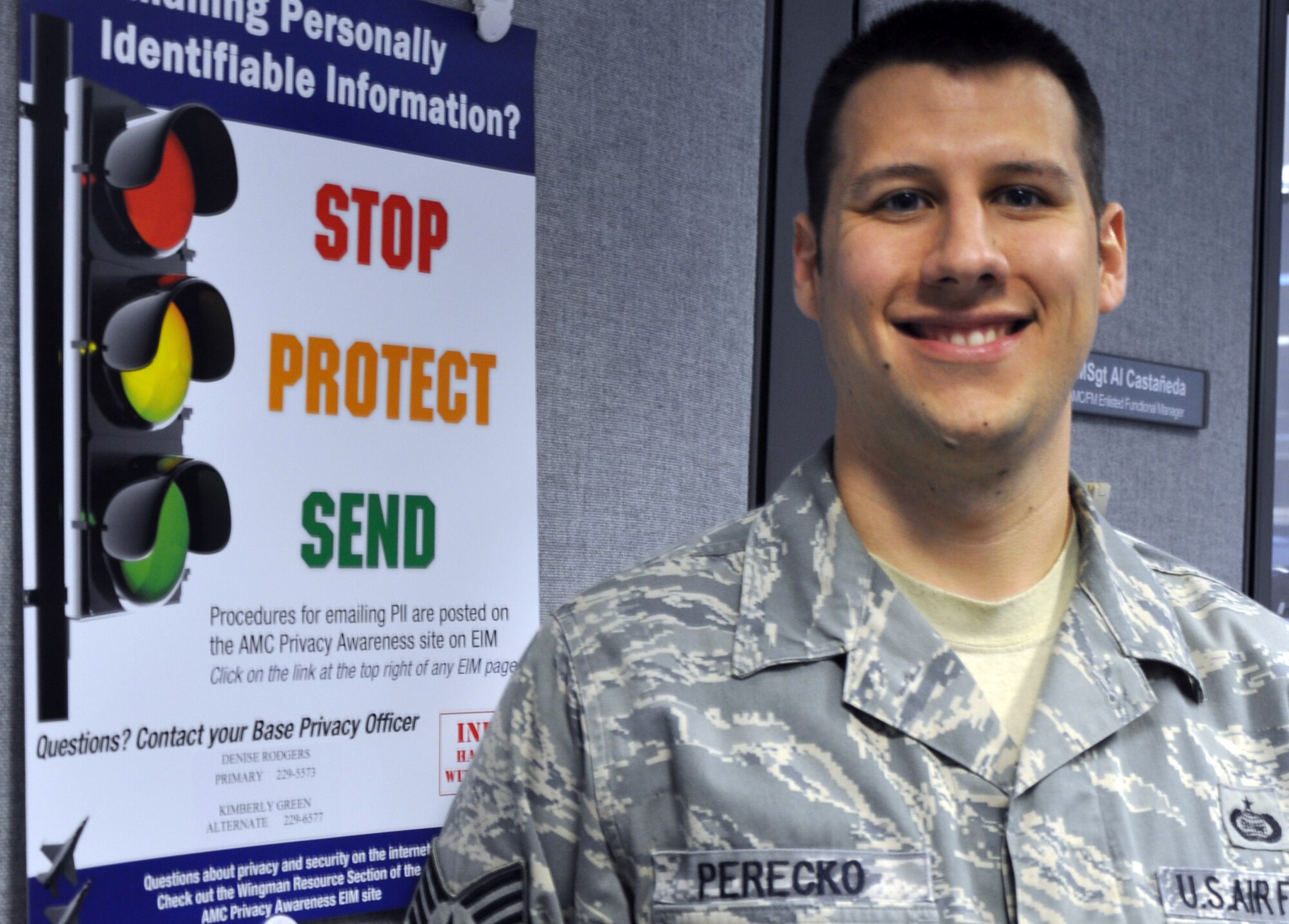 Staff Sgt. Robert Perecko, from the 618th Air Operations Center (Tanker Airlift Control Center), is shown near an operations security poster at the Headquarters Air Mobility Command building at Scott Air Force Base, Ill., on April 20, 2012. Perecko was named the 2011 Air Force Operations Security NCO of the Year. He works as the information operations fused communication NCO in charge at the 618th AOC (TACC). (U.S. Air Force photo/Senior Airman Amber Kelly-Herard)