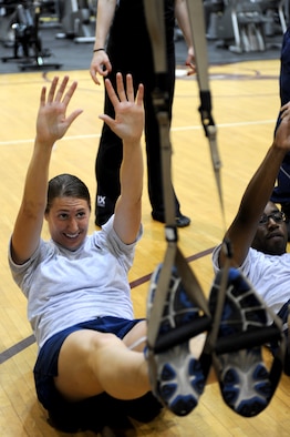 U.S. Air Force Staff Sgt. Leiah Cooper performs a sit-up during a Total Body Resistance Exercise and Suspension Training course at the base fitness center on Seymour Johnson Air Force Base, N.C., April 19, 2012. Movements using the TRX integrate strength and balance into a single dynamic format that exhaust the nervous system at a high level and maximizes the benefits of bodyweight exercise for faster results. Cooper, 4th Maintenance Operations Squadron quality assurance inspector, hails from Covington, La. (U.S. Air Force photo/Staff Sgt. Courtney Richardson/Released)