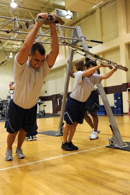 U.S. Air Force Tech. Sgts Andrew Garrett and Jennifer Gutierrez perform standing roll outs during a Total Body Resistance Exercise and Suspension Training course at the base fitness center on Seymour Johnson Air Force Base, N.C., April 19, 2012. TRX training utilizes gravity and movement to generate neuromuscular response. Garrett, 4th Aerospace Medicine Squadron dental lab technician, hails from Portland, Tenn. Gutierrez, 567th Red Horse Squadron training manager, is from Fayetteville, N.C. (U.S. Air Force photo/Staff Sgt. Courtney Richardson/Released)