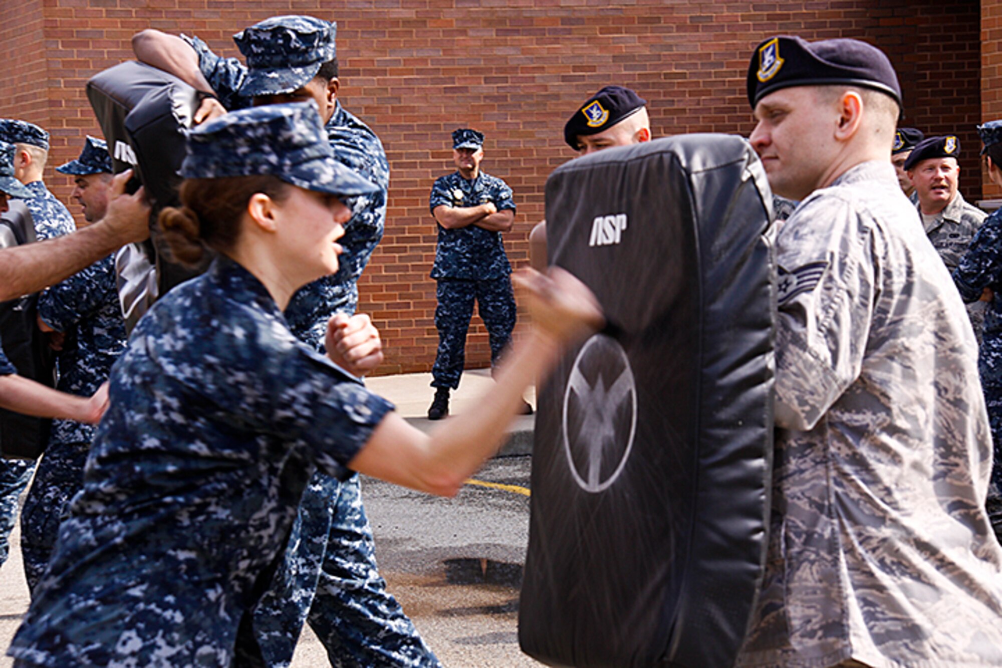 Lt. j.g. Jeffrey Emerick, Commanding Officer of Pittsburgh Naval Security Forces, Naval Operation Support Center, watches over a joint military security forces training at the 911th Airlift Wing, April 15, 2012. The Naval Security Forces is working hand in hand with the 911th AW Security Forces to promote joint exercises such as learning how to stop an aggressor using multiple objects, such as a baton. (U.S. Air Force photo by Airman 1st Class Justyne Obeldobel/Released)