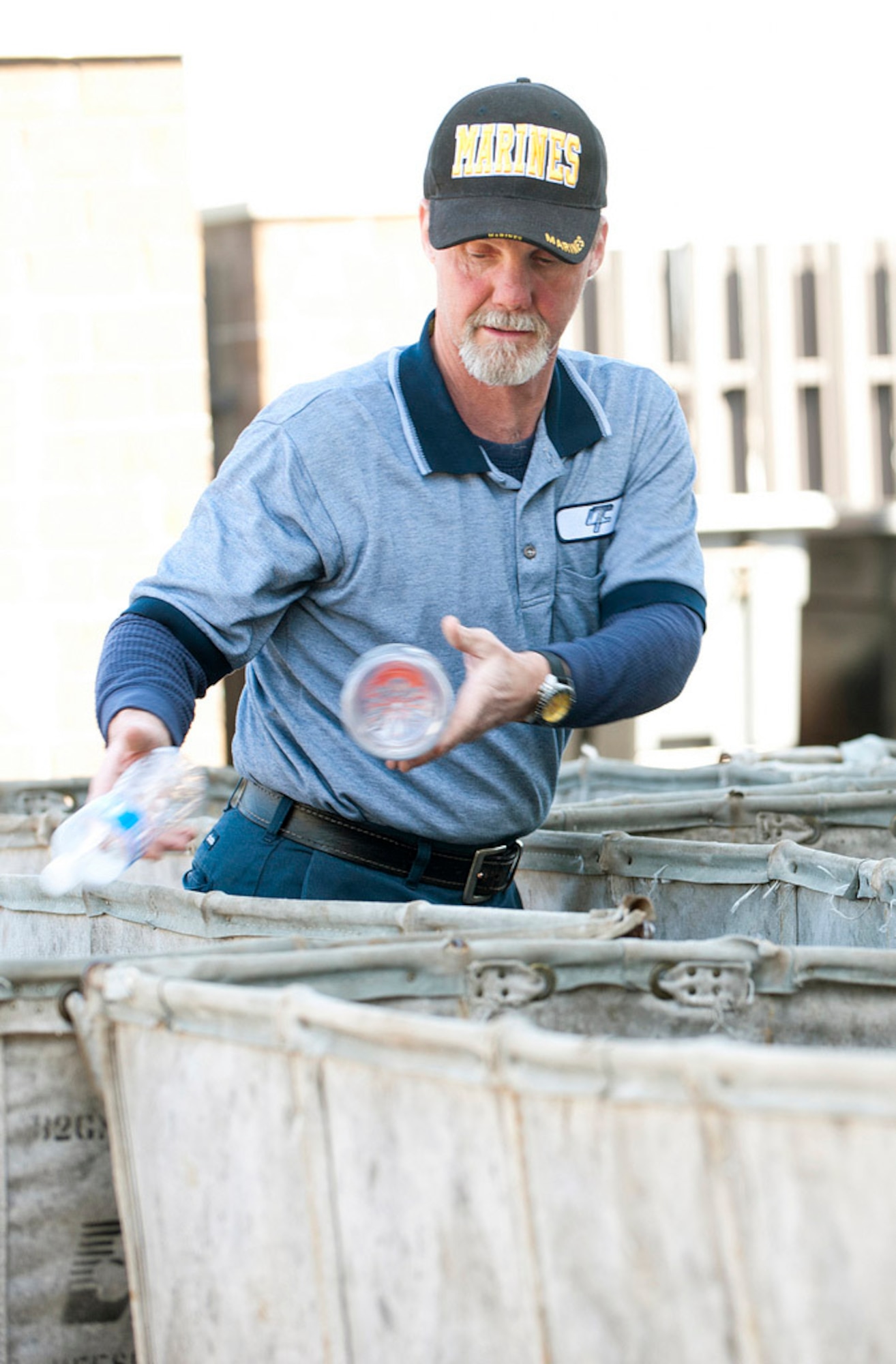 David McGee, of the Joint Base Recycling Center, fills hampers with plastic and glass bottles here. The bottles are separated from other recyclables and shipped to the main recycling facility in Mount Holly, N.J. Recycled materials are repurposed to create new products which decreases waste. (U.S. Air Force Photo by Russ Meseroll/Released)
