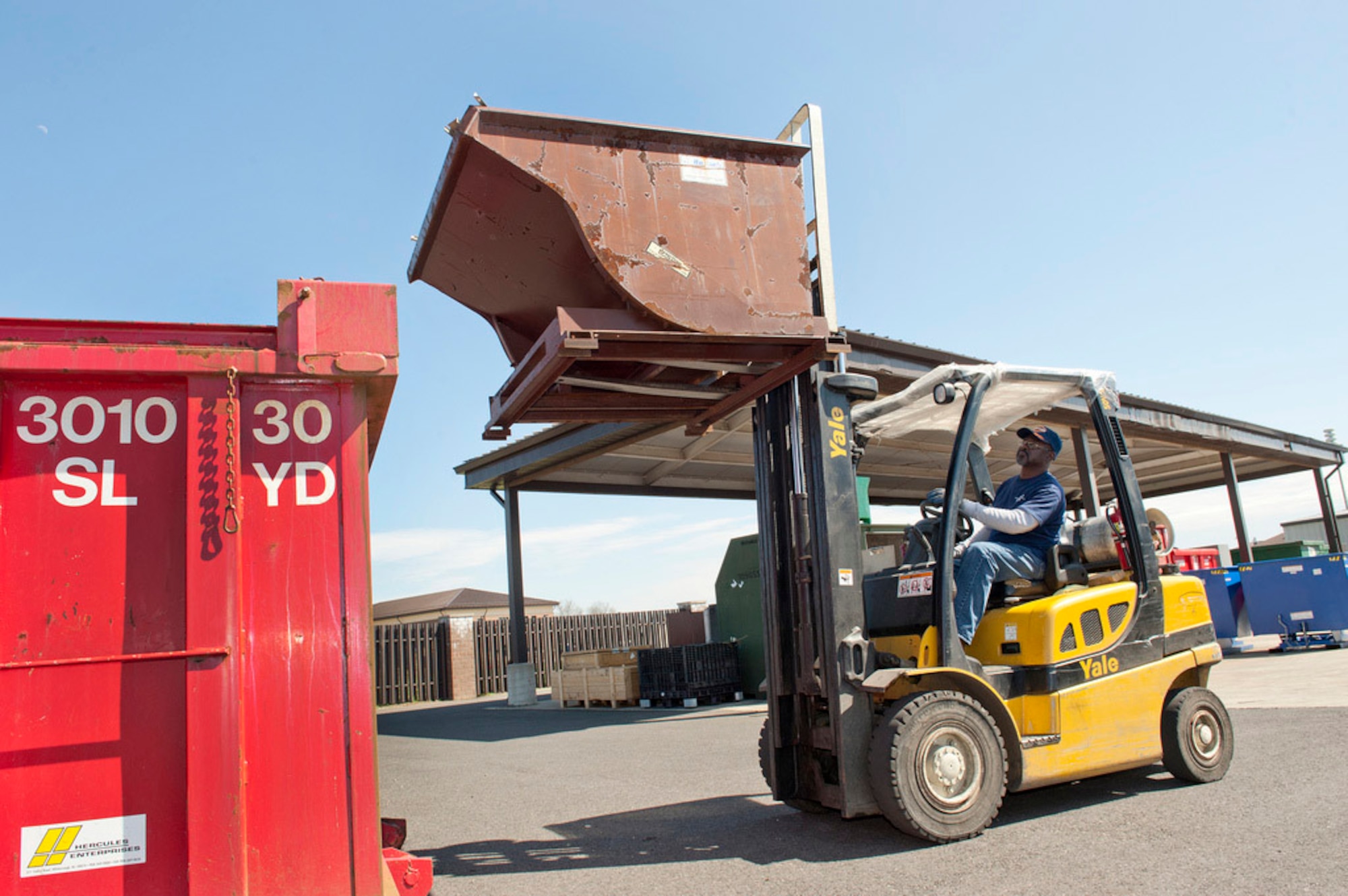Clarence Lewis, Joint Base Recycling Center project manager, loads aluminum products into the roll container here. Joint Base McGuire-Dix-Lakehurst's recycling efforts contribute globally by reducing the amount of resources wasted to create new products. (U.S. Air Force Photo by Russ Meseroll/Released)