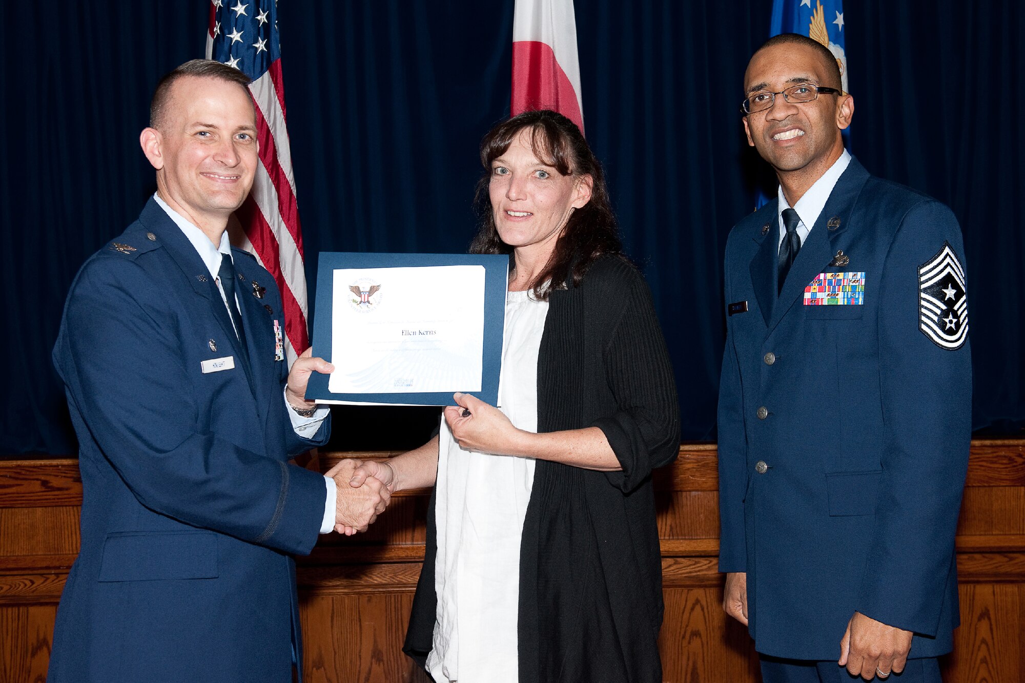 YOKOTA AIR BASE, Japan -- Ellen Kerns (center) receives the Presidential Volunteer Service Gold Awards from Col. Bill Knight (left), 374th Airlift Wing commander, and Command Chief Master Sgt. Ronald Draper (right), 374th Airlift Wing, during Yokota's Annual Volunteer Recognition Ceremony at Yokota Air Base, Japan, April 19, 2012. The Presidential Volunteer Service Award recognizes individuals and groups for their dedicated service over the past year and for their cumulative lifetime volunteer service. The gold award winners have provided and documented over 500 hours of volunteer service in 2011. (U.S. Air Force photo/Osakabe Yasuo)