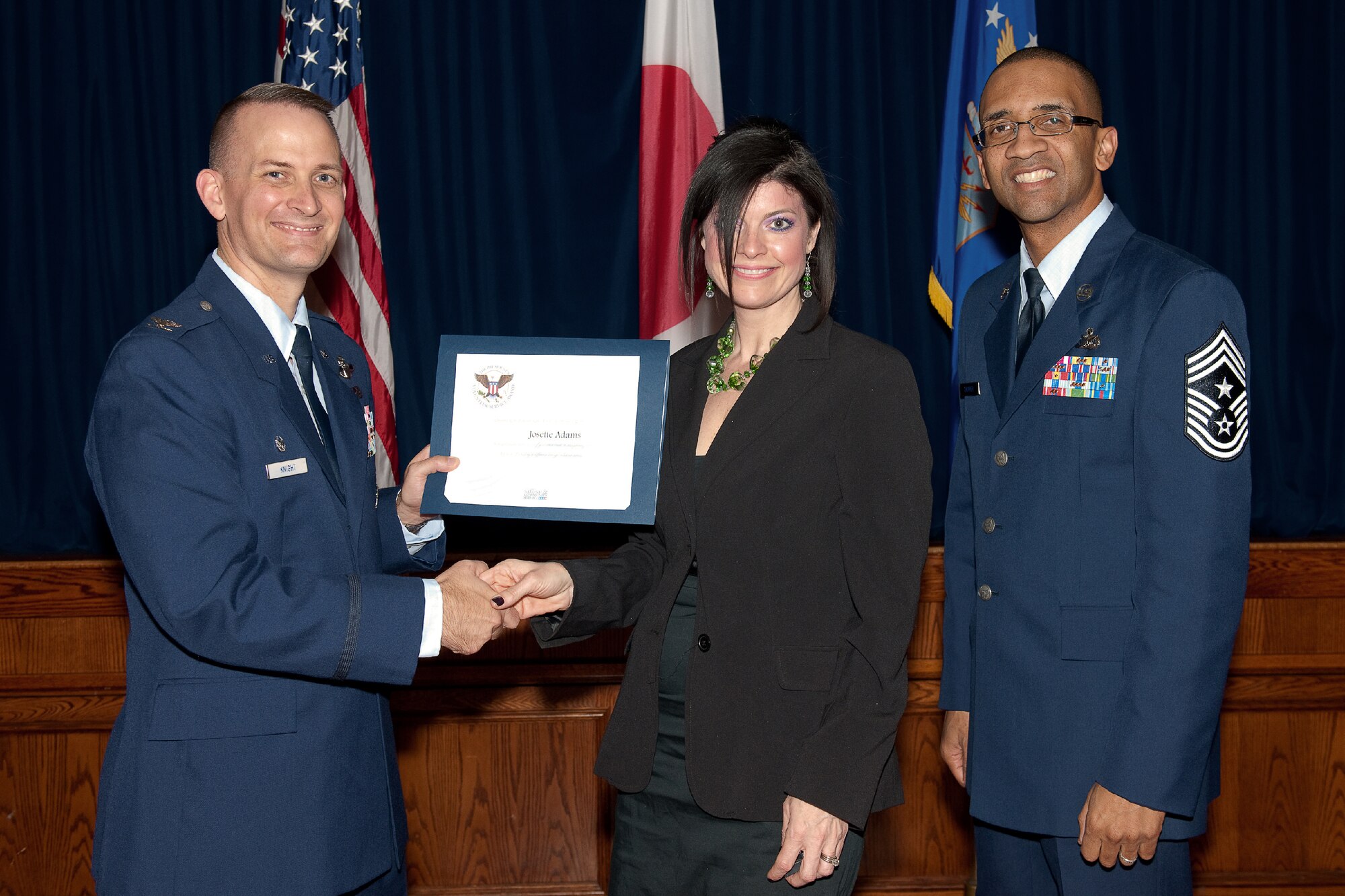 YOKOTA AIR BASE, Japan -- Josette Adams (center) receives the Presidential Volunteer Service Gold Awards from Col. Bill Knight (left), 374th Airlift Wing commander, and Command Chief Master Sgt. Ronald Draper (right), 374th Airlift Wing, during Yokota's Annual Volunteer Recognition Ceremony at Yokota Air Base, Japan, April 19, 2012. The Presidential Volunteer Service Award recognizes individuals and groups for their dedicated service over the past year and for their cumulative lifetime volunteer service. The gold award winners have provided and documented over 500 hours of volunteer service in 2011. (U.S. Air Force photo/Osakabe Yasuo)