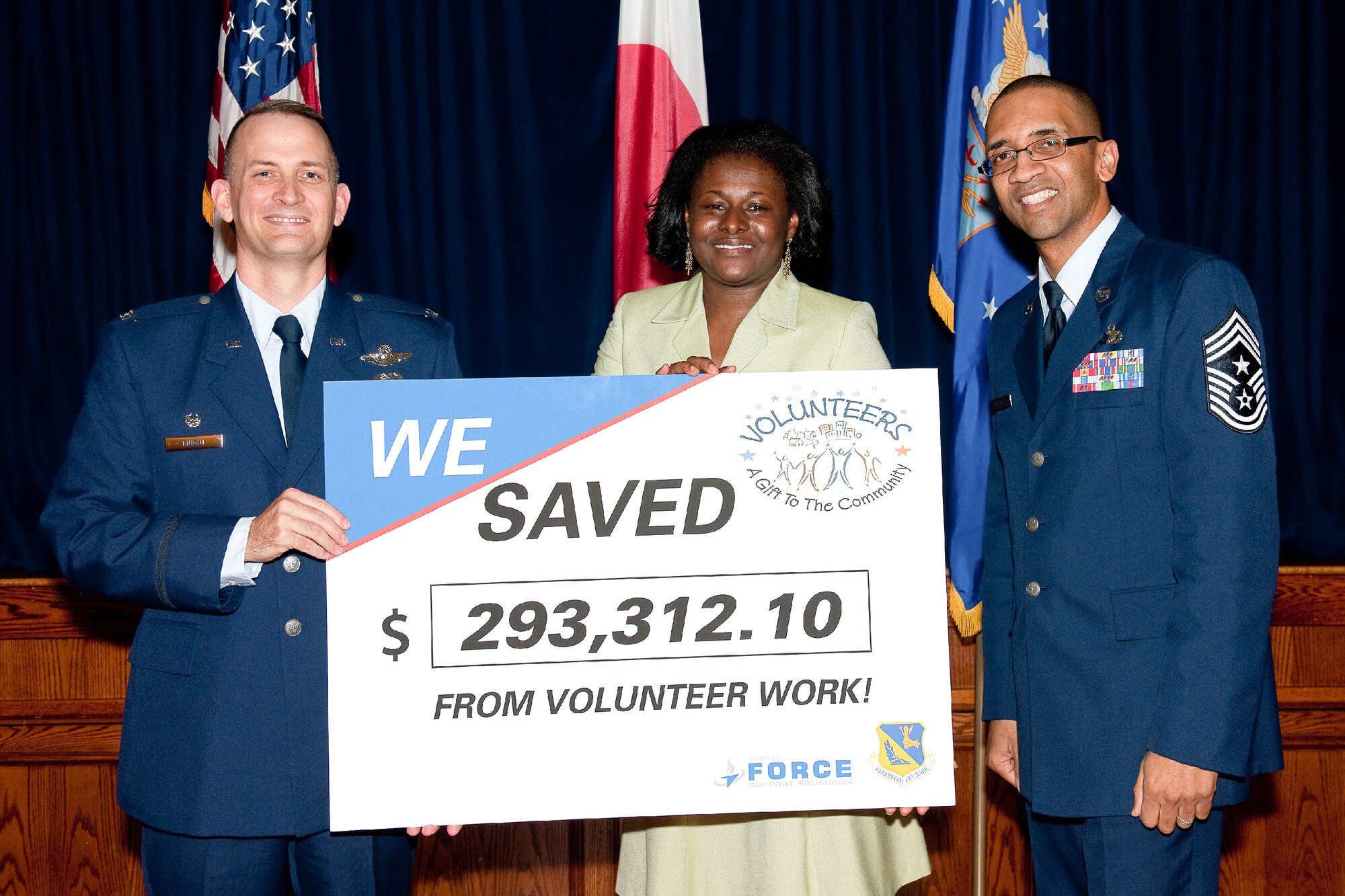 YOKOTA AIR BASE, Japan -- Col. Bill Knight (left), 374th Airlift Wing commander, Kimberly Richberg (center), 374th Force Support Squadron community readiness specialist, and Command Chief Master Sgt. Ronald Draper (right), 374th Airlift Wing, pose with a board during the Yokota annual Volunteer Recognition Ceremony at Yokota Air Base, Japan, April 19, 2012. Volunteers saved Yokota nearly $300,000 in 2011 in various community programs. (U.S. Air Force photo/Osakabe Yasuo)