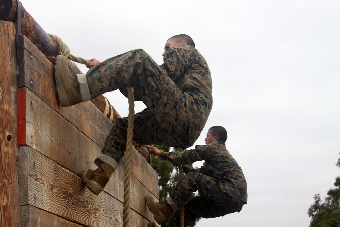 Company H recruits use a rope to climb over a wall April 23 aboard Marine Corps Recruit Depot San Diego. This is one of 12 obstacles that recruits had to complete while doing the Confidence Course during week three. The course not only helps the recruits physically but also mentally. They will complete an advanced version in a week.