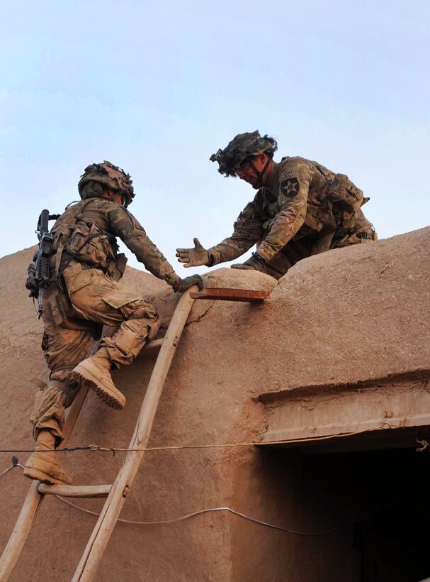 U.S. Army Pvt. Daniel Rodriguez, left, climbs a ladder to provide security on a roof top as U.S. Army Spc. Taylor Middlebrooks, right, gives him a hand during Operation Eagle Mountain in Didar, Afghanistan, April 14, 2012. Rodriguez and Middlebrooks are assigned to Company B, 5th Battalion, 20th Infantry Regiment.