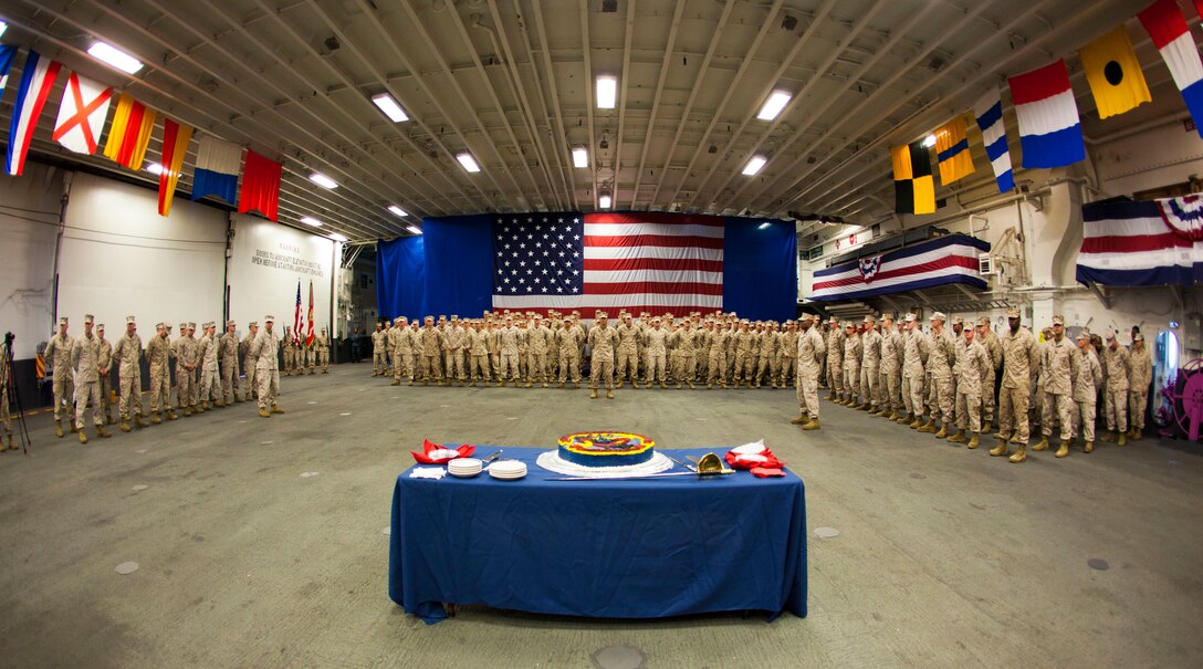 Marines and sailors assigned to 26th Marine Expeditionary Unit and Company C, 1st Battalion, 6th Marine Regiment, stand in formation to celebrate the 45th birthday of 26th MEU in the hanger bay of USS Wasp (LHD-1), April 24, 2012. 26th MEU was activated in 1967, and since then, has successfully completed various operations and exercises spanning across the globe. In a dynamic and ever changing world, the 26th MEU has always been a certain force in an uncertain world. (U.S. Marine Corps photo by Cpl. Christopher Q. Stone/Released)