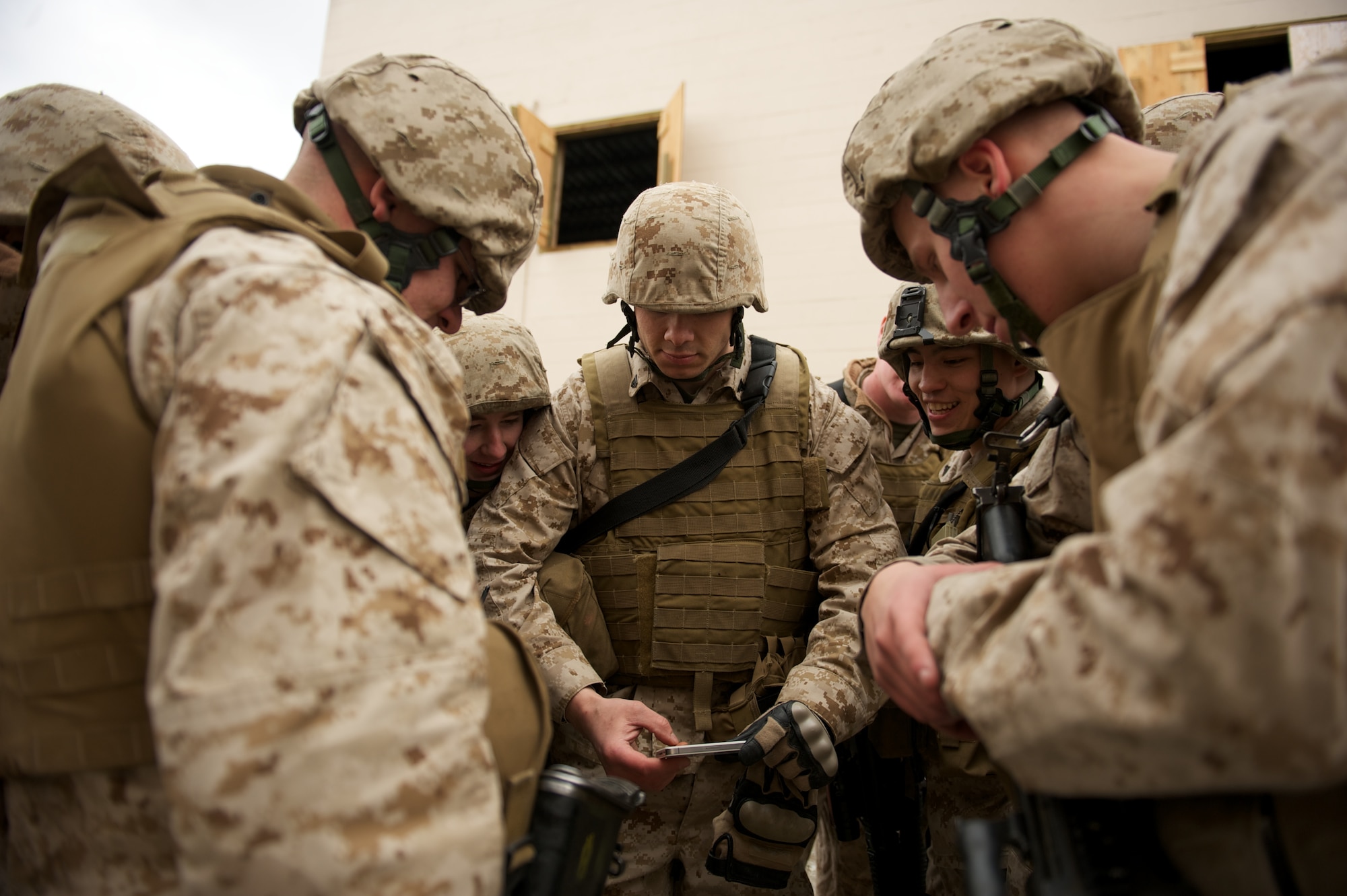 JOINT BASE ELMENDORF-RICHARDSON, Alaska -- Marine Cpl. Terrence Nuss (center), a D Company, Anti-Terrorism Battalion squad leader, shares smartphone footage of his Marines maneuvering during training in urban operations April 21 at JBER's Baumeister City MOUT Complex. (U.S. Air Force photo/David Bedard)