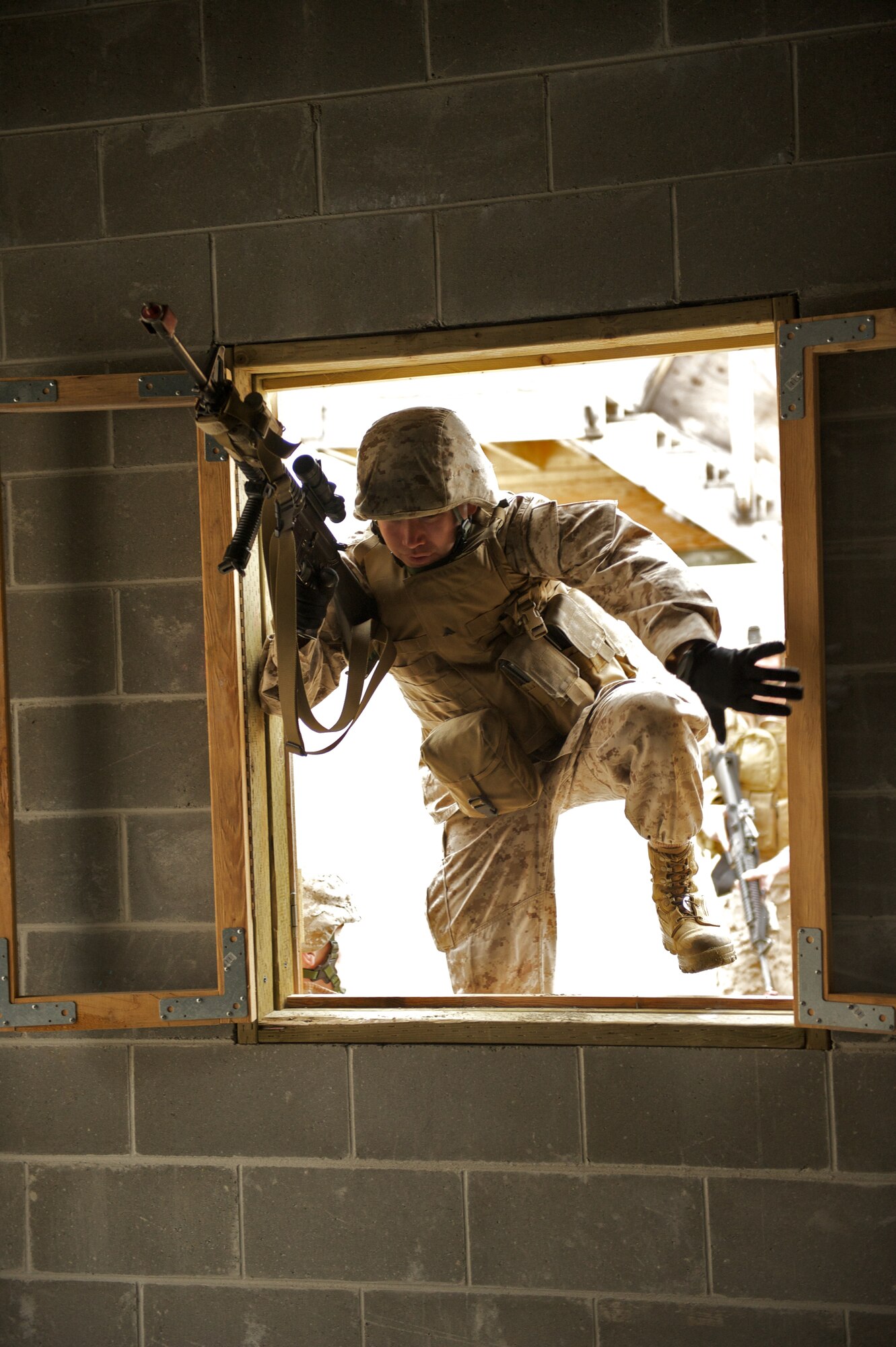 JOINT BASE ELMENDORF-RICHARDSON, Alaska -- Lance Cpl. Matthew Alexander, D Company, Anti-Terrorism Battalion, of Anchorage, enters a window April 21 during training in urban operations at JBER's Baumeister City MOUT Complex. (U.S. Air Force photo/David Bedard)