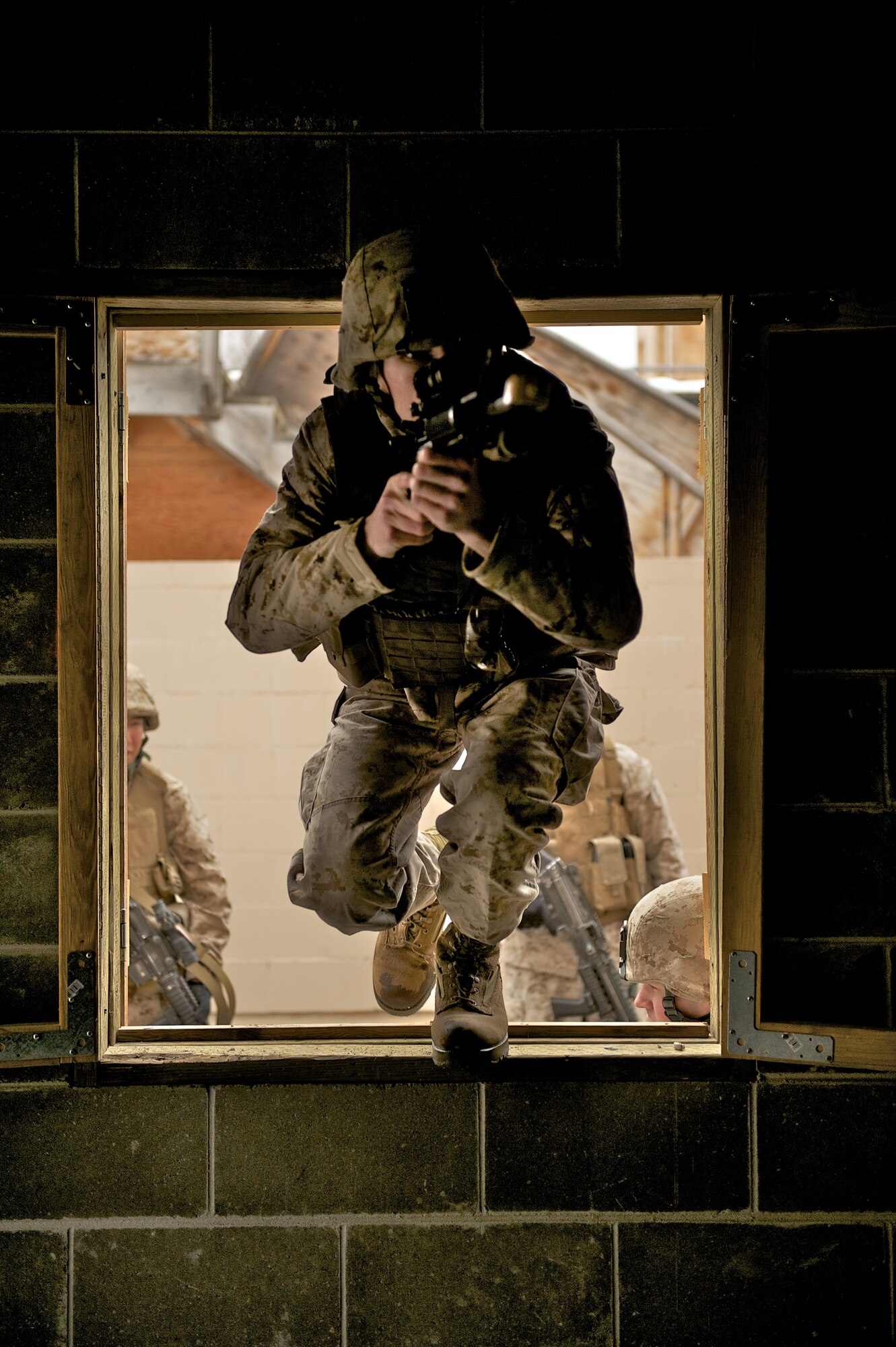 JOINT BASE ELMENDORF-RICHARDSON, Alaska -- Marine Sgt. Craig Thibedeaux, D Company, Anti-Terrorism Battalion, enters a window April 21 during training in urban operations at JBER's Baumeister City MOUT Complex. (U.S. Air Force photo/David Bedard)