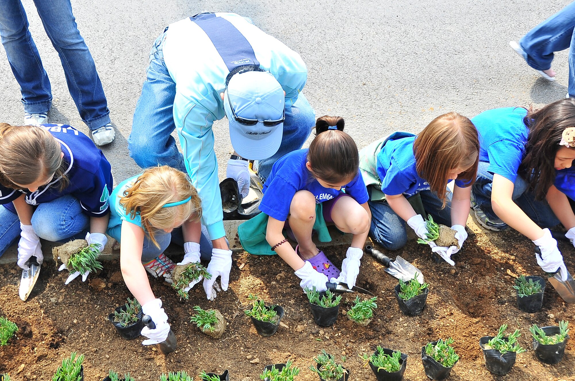 Osan Girl Scouts honor Arbor Day and Earth Day by planting 200 flowers and 10 bushes worth approximately $800 here, April 20, 2012. Before planting, each scout received a brief on the history behind the day’s celebration and the importance of the cause. The flowers and trees were planted near the Osan American Elementary School’s student drop-off zone. (U.S. Air Force photo/Senior Airman Adam Grant)