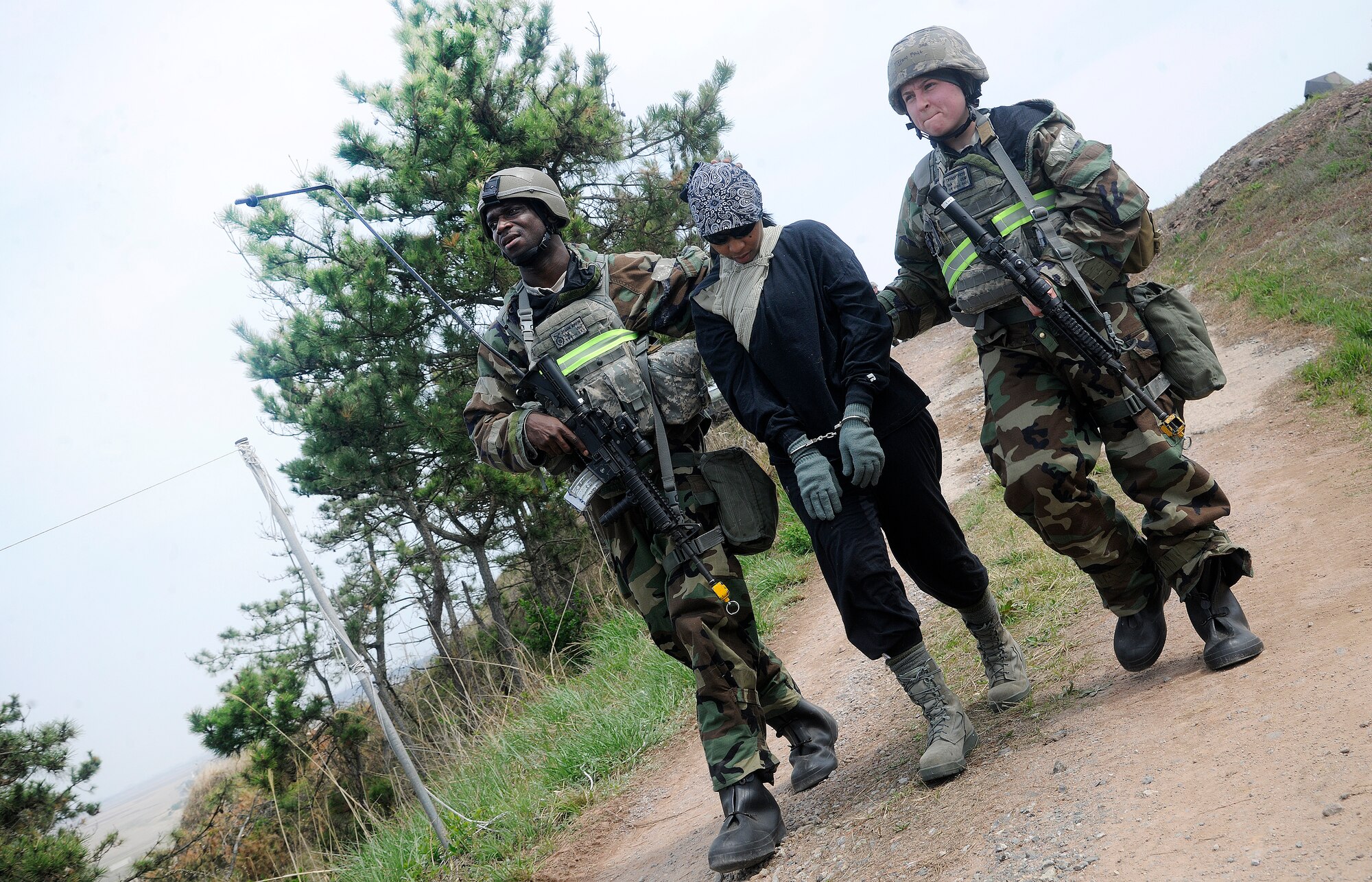Staff Sgt. Jermaine Morrow and Senior Airman Tiffany Frye, 8th Security Forces Squadron force response leaders, escort a mock prisoner of war requiring medical attention during an operational readiness exercise at Kunsan Air Base, Republic of Korea, April 24, 2012. BEVERLY MIDNIGHT 12-02 is the last phase of inspections by the Pacific Air Forces Inspector General Team.  The Wolf Pack will find out the inspection results on May 2 after the IG Team has finalized their report. (U.S. Air Force photo/Staff Sgt. Rasheen A. Douglas)