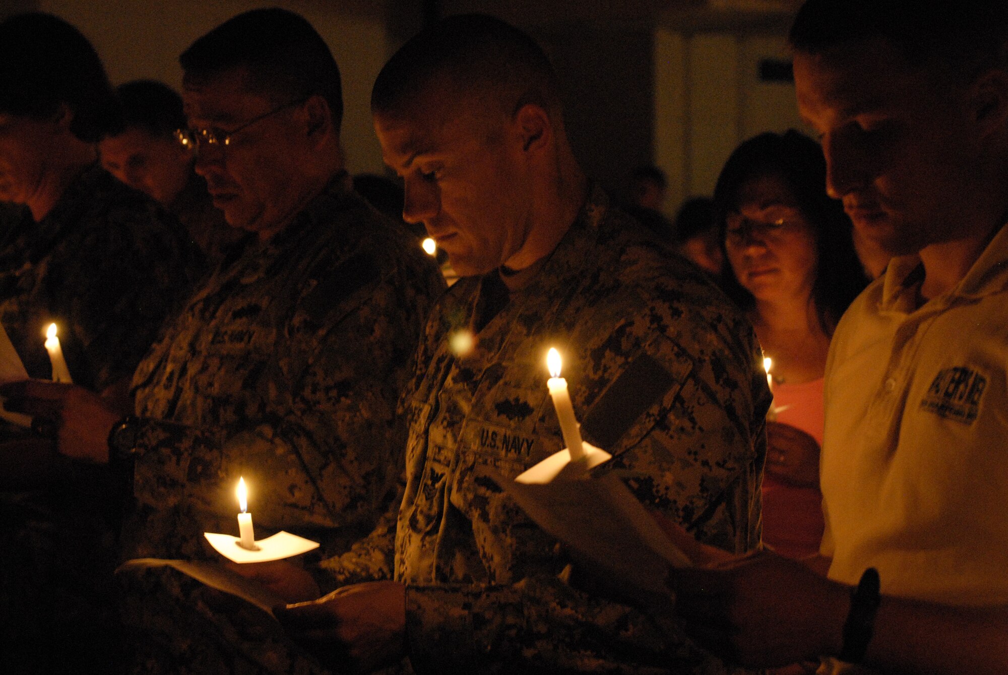 Service members and civilians participate in a traditional Jewish memorial prayer during the Holocaust Memorial observance at Chapel 1 on Kadena Air Base, Japan, April 19, 2012. The prayer was recited in remembrance of the millions of victims of the Holocaust. (U.S. Air Force photo by Airman 1st Class Malia Jenkins/Released)