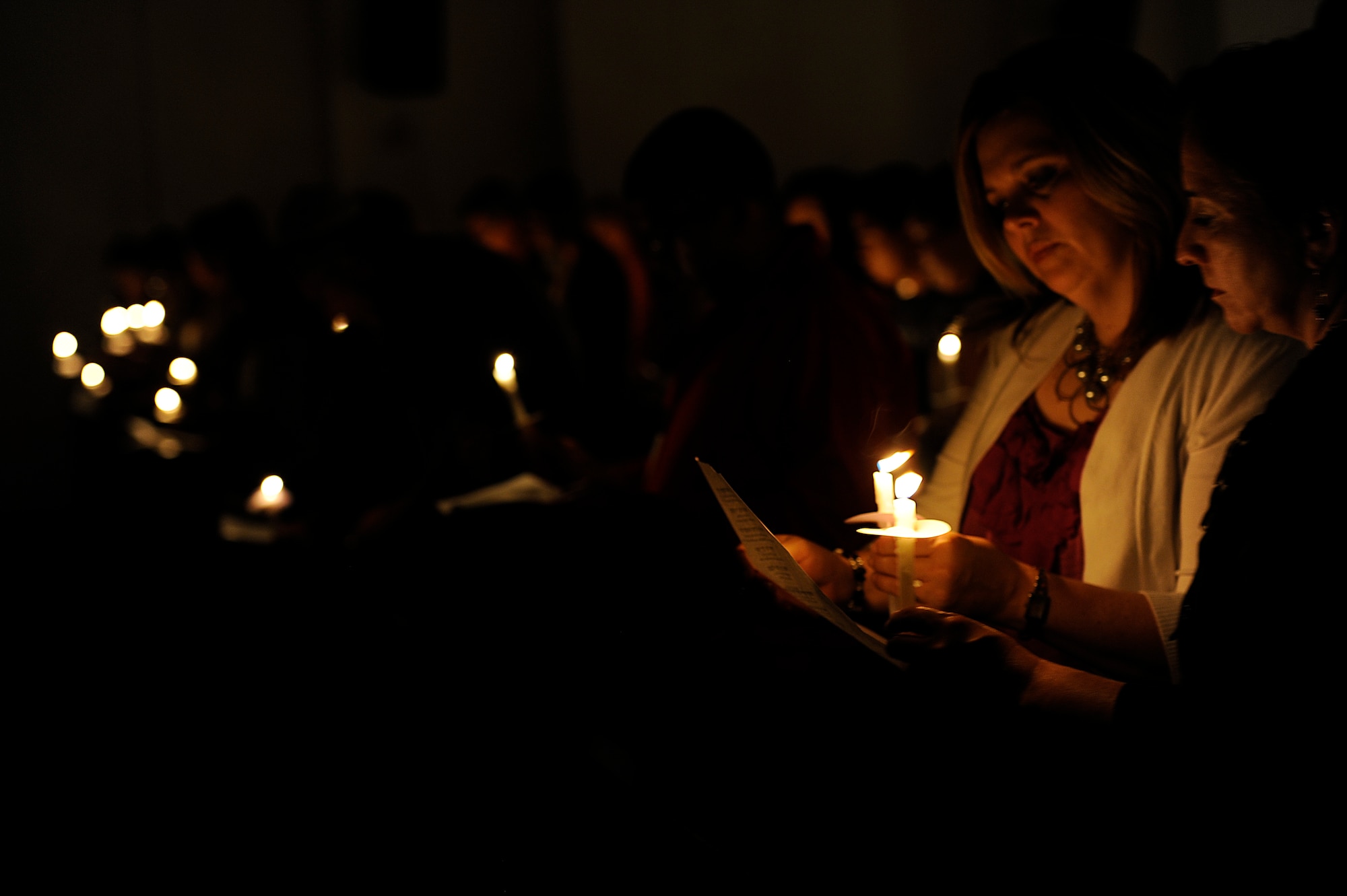 Sheila Sellers (left), wife of U.S. Air Force Chaplain (Maj.) Randy Sellers, 18th Wing senior protestant chaplain, and Monica McCain, wife of Chaplain (Col.) Steven McCain, 18th Wing chaplain, read a Hebrew prayer by candlelight during the Holocaust Memorial observance candlelight vigil at Chapel 1 on Kadena Air Base, Japan, April 19, 2012. Hundreds of people who attended the ceremony listened to a guest speaker who survived the Holocaust and joined a candlelight vigil and prayer in remembrance of those who died from the genocide. (U.S. Air Force photo by Airman 1st Class Maeson L. Elleman/Released)
