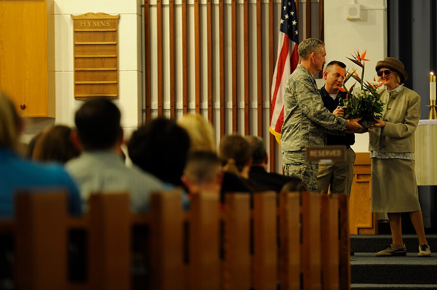 (From left to right) U.S. Air Force Chaplain (Col.) Steven McCain, 18th Wing chaplain, and Chaplain (Capt.) Kevin Humphrey, 18th Wing protestant chaplain, give Viola Milne flowers in appreciation at Chapel 1 on Kadena Air Base, Japan, April 19, 2012. Milne is a Jewish Holocaust survivor who shared her story as part of the Holocaust Memorial observance at the chapel. (U.S. Air Force photo by Airman 1st Class Maeson L. Elleman/Released)