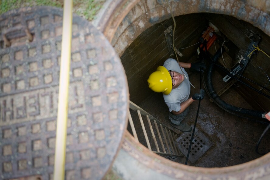 U.S. Air Force Airman 1st Class Oliver Martinez, 18th Communications Squadron cable systems journeyman, pulls fiber optic cable through a maintenance hole on Kadena Air Base, Japan, April 24, 2012. Airmen from the 18th CS ran a mile of cable in order to provide high-speed Internet to Department of Defense Dependent Schools on base. (U.S. Air Force photo by Airman 1st Class Hailey R. Davis/Released)