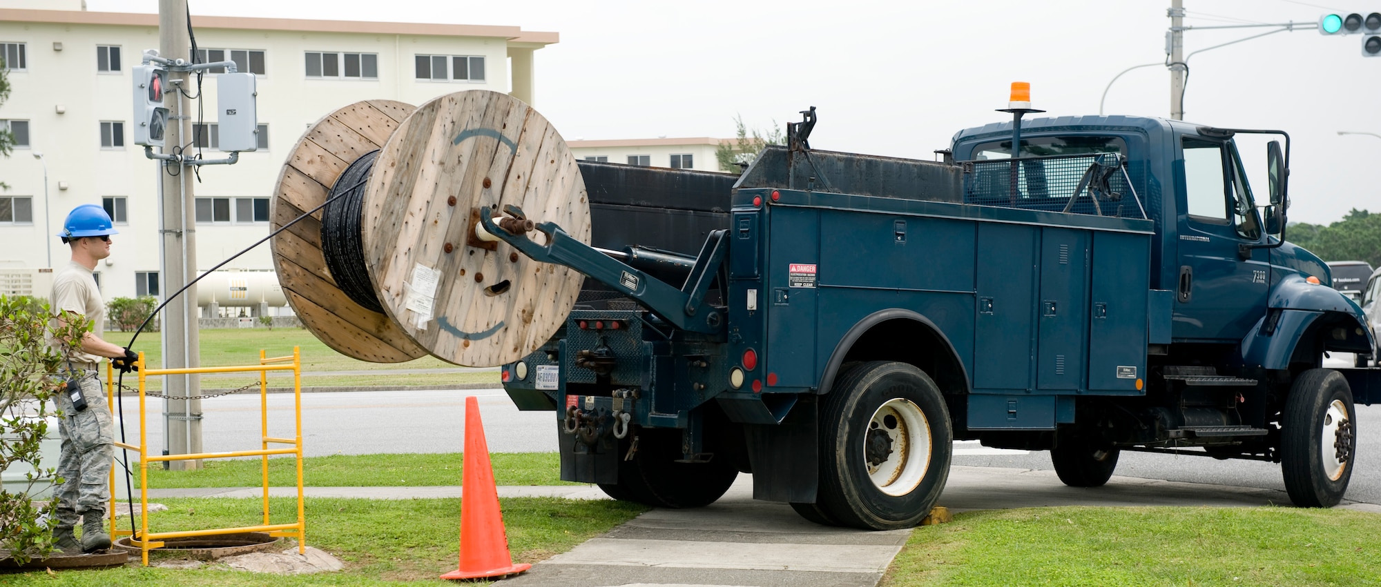 U.S. Air Force Staff Sgt. Adam T. Lesperance, 18th Communications Squadron cable systems supervisor, feeds fiber optic cable into a maintenance hole on Kadena Air Base, Japan, April 24, 2012. The cable is part of a 21st century initiative to provide high-speed Internet to eight Department of Defense Dependent Schools and an administration building on base. (U.S. Air Force photo by Airman 1st Class Hailey R. Davis/Released)