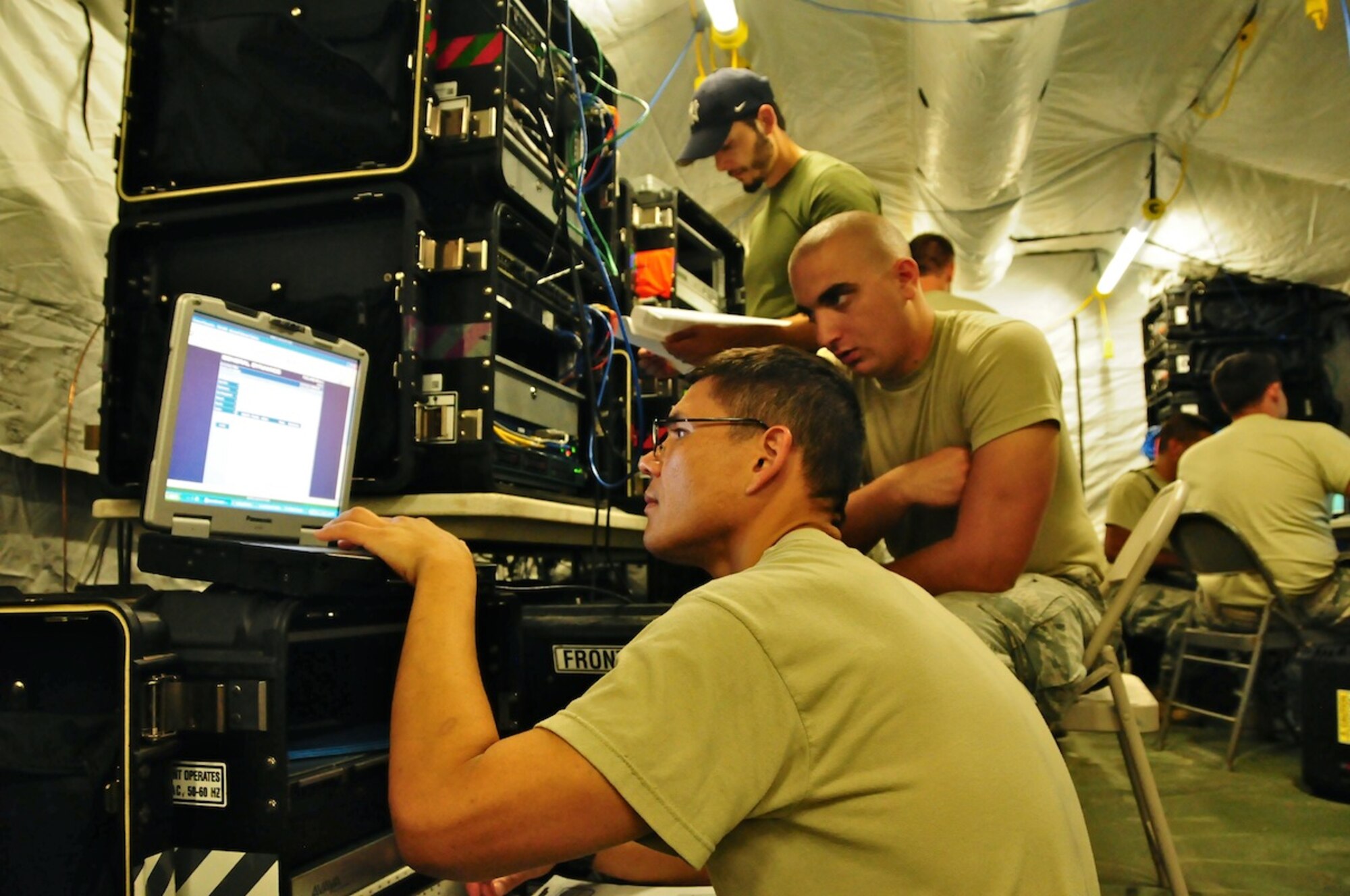 Senior Airman Brandon Hudson, 644th Combat Communications Squadron cyber transport technician, watches as Staff Sgt. David Popovich, 644 CBCS cyber transport technician, works on setting up the network for the simulated Forward Operating Base Dragon Hill April 19. The 644 CBCS is conducting a deployment exercise from April 16 to 27 in order to test their capabilities in the field and improve their war-fighting capabilities.  (U.S. Air Force photo by Airman 1st Class Marianique Santos)  