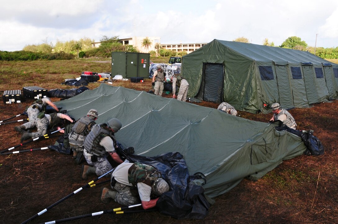 The 644th Combat Communications Squadron members work together to build tents at the simulated Forward Operating Base Dragon Hill April 19. The 644 CBCS is conducting a deployment exercise from April 16 to 27 in order to test their capabilities in the field and improve their war-fighting capabilities.  (U.S. Air Force photo by Airman 1st Class Marianique Santos)