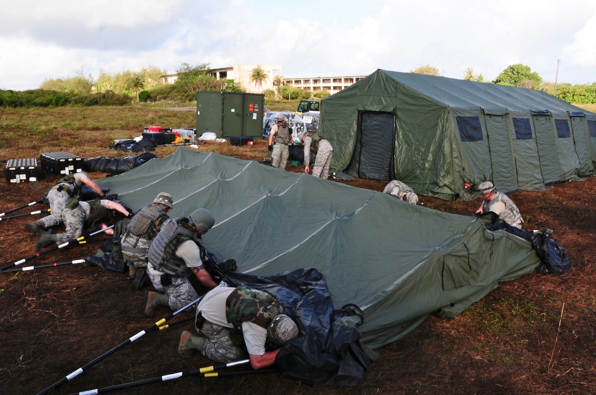 The 644th Combat Communications Squadron members work together to build tents at the simulated Forward Operating Base Dragon Hill April 19. The 644 CBCS is conducting a deployment exercise from April 16 to 27 in order to test their capabilities in the field and improve their war-fighting capabilities.  (U.S. Air Force photo by Airman 1st Class Marianique Santos)