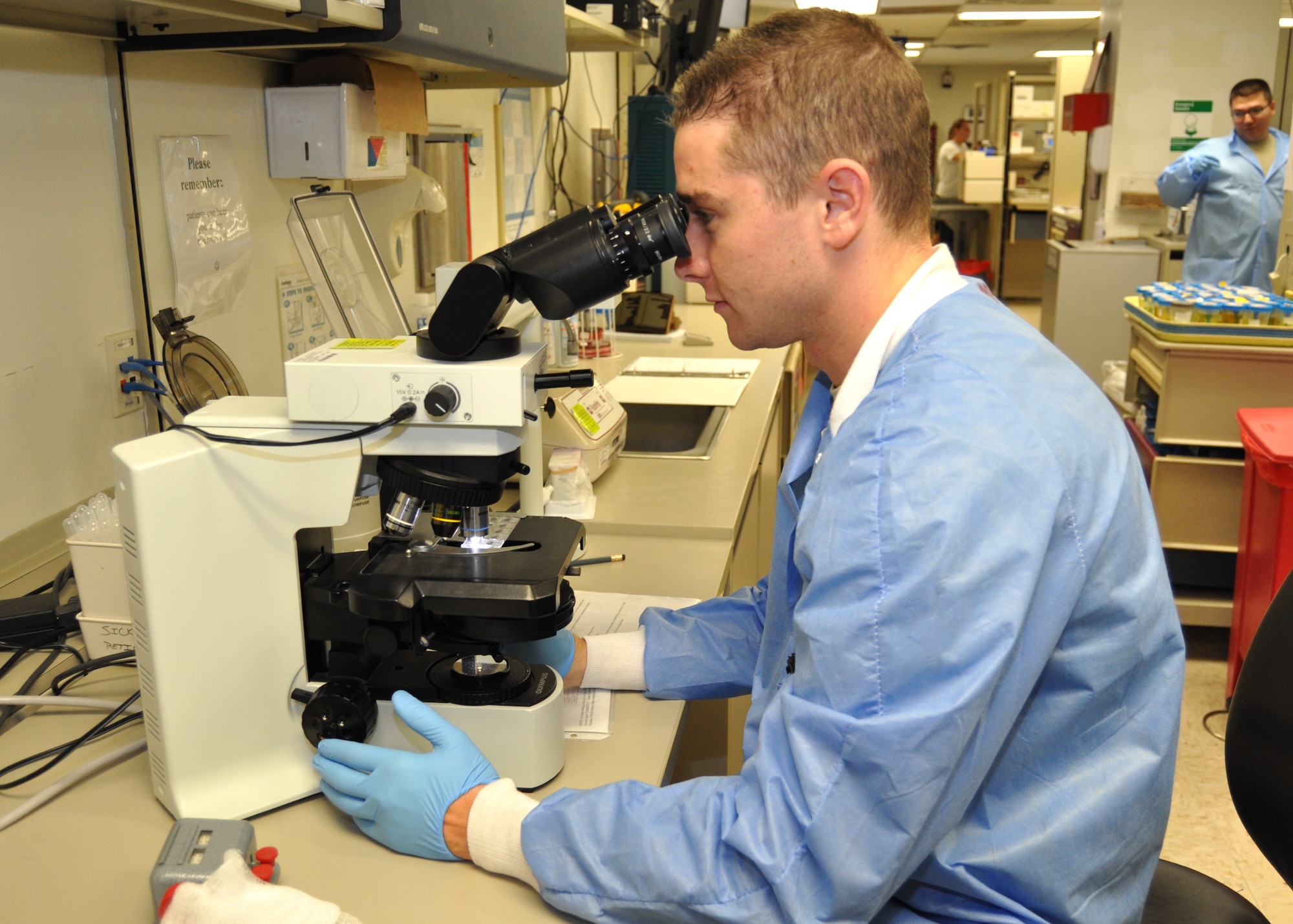 Clinical lab technician Senior Airman Christopher Boyd, 81st Diagnostics and Therapeutics Squadron, uses a microscope to examine a stained blood slide for abnormal cells at the Keesler Hospital, Keesler Air Force Base, Miss. Identification of abnormal cells could aid providers in diagnosing patients with various conditions like anemia or even cancer. Boyd was one of the many lab technicians honored for National Medical Laboratory Professionals Week April 22-28, 2012.  (U.S. Air Force photo by Steve Pivnick)