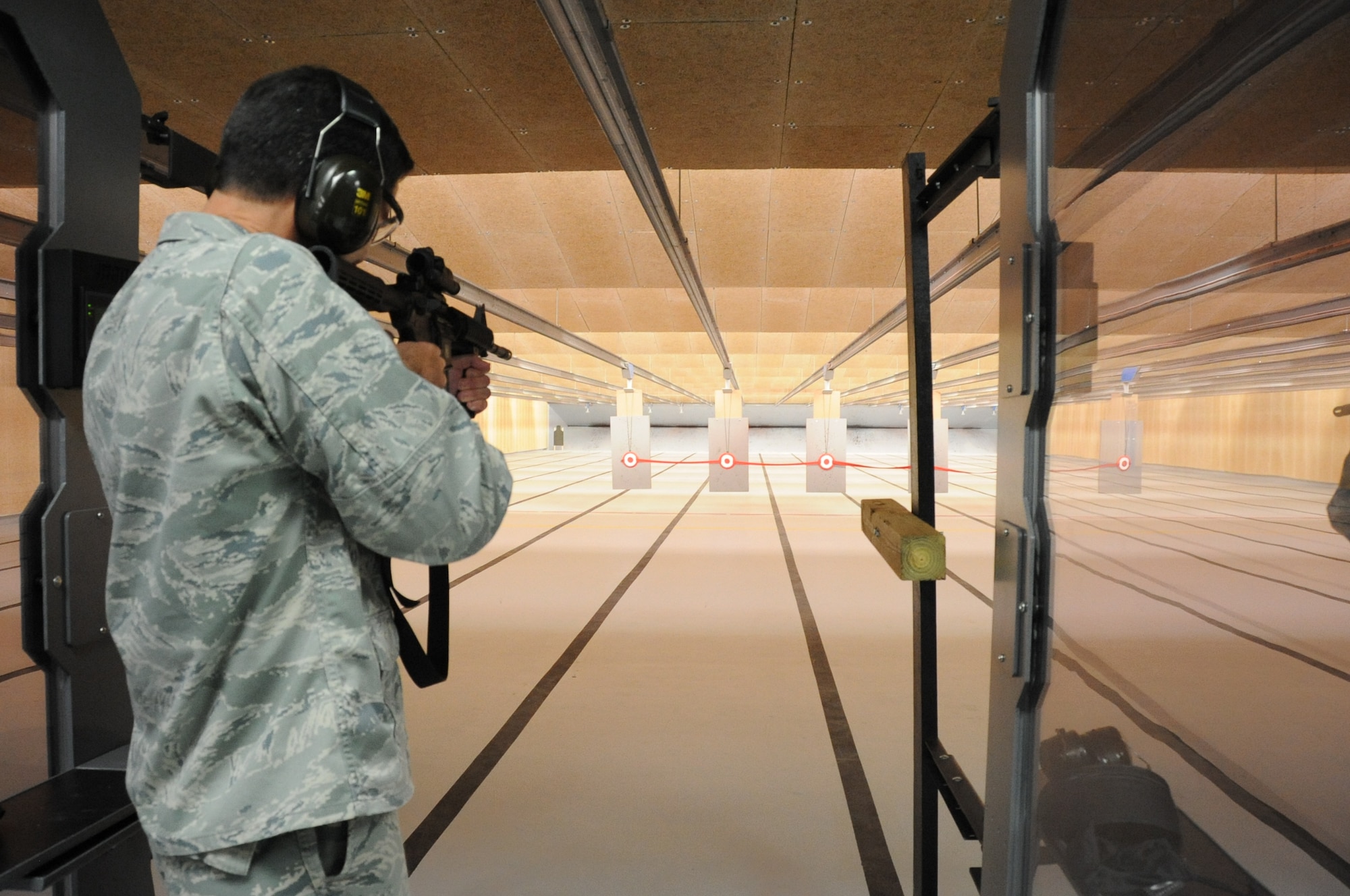 Col. Rodney Berk, 81st Mission Support Group commander, fires an M4 Carbine rifle at the target supporting the ribbon during the ribbon cutting ceremony for the 81st Security Forces Squadron Firing Range building April 20, 2012, Keesler Air Force Base, Miss. The small arms firing range is a $5.3 million project that will provide weapons training and qualification to 81st Security Forces Squadron members and those who need weapons qualification for deployments. Previously, to meet this requirement, Keesler members had to travel 17 miles to the Navy's combat arms training and maintenance facility at Camp Keller, Miss.  Construction began in November 2011 and the safety test was completed March 28.  (U.S. Air Force photo by Kemberly Groue)