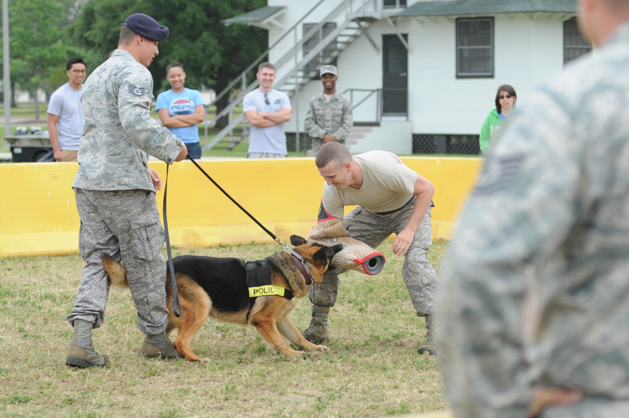 Staff Sgt. Jose Orama, 81st Security Forces Squadron dog handler, and his military working dog, Gino, demonstrate the abilities of a military working dog when capturing “bad guys,” with the help of Staff Sgt. Javonnia Peak, 81st SFS, during Operation Hero April 21, 2012, at Keesler Air Force Base, Miss.  Operation Hero takes place twice a year.  The event was designed to help children better understand what a deployment is and what happens when their parents deploy. (U.S. Air Force photo by Kemberly Groue)