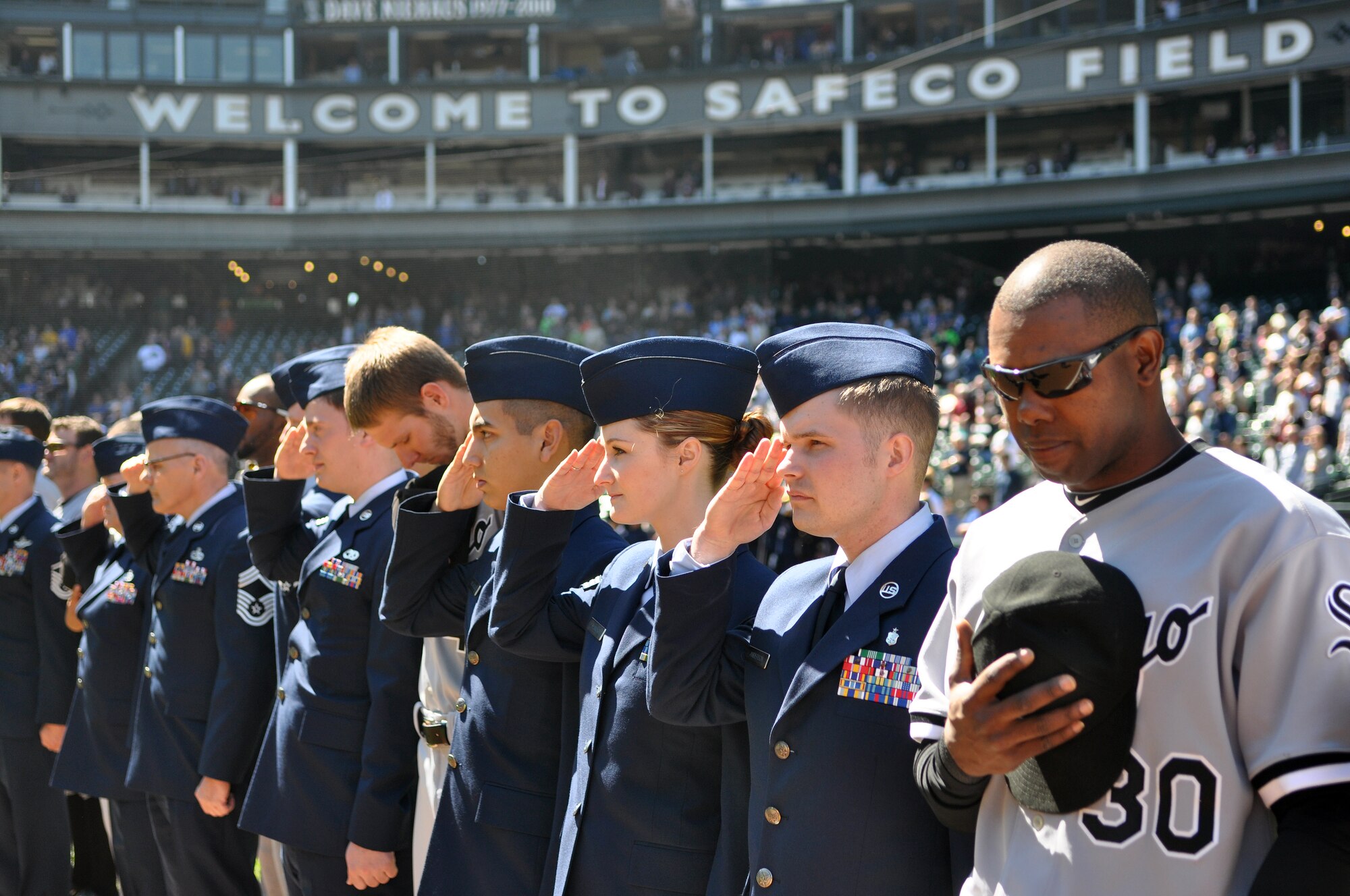 62nd Airlift Wing Airmen and other military representatives salute during the National Anthem as they stand beside Chicago White Sox players at the 11th annual Seattle Mariners Armed Forces Day April 21, 2012, at Safeco Field in Seattle, Wash. (U.S. Air Force photo/Senior Airman Leah Young)