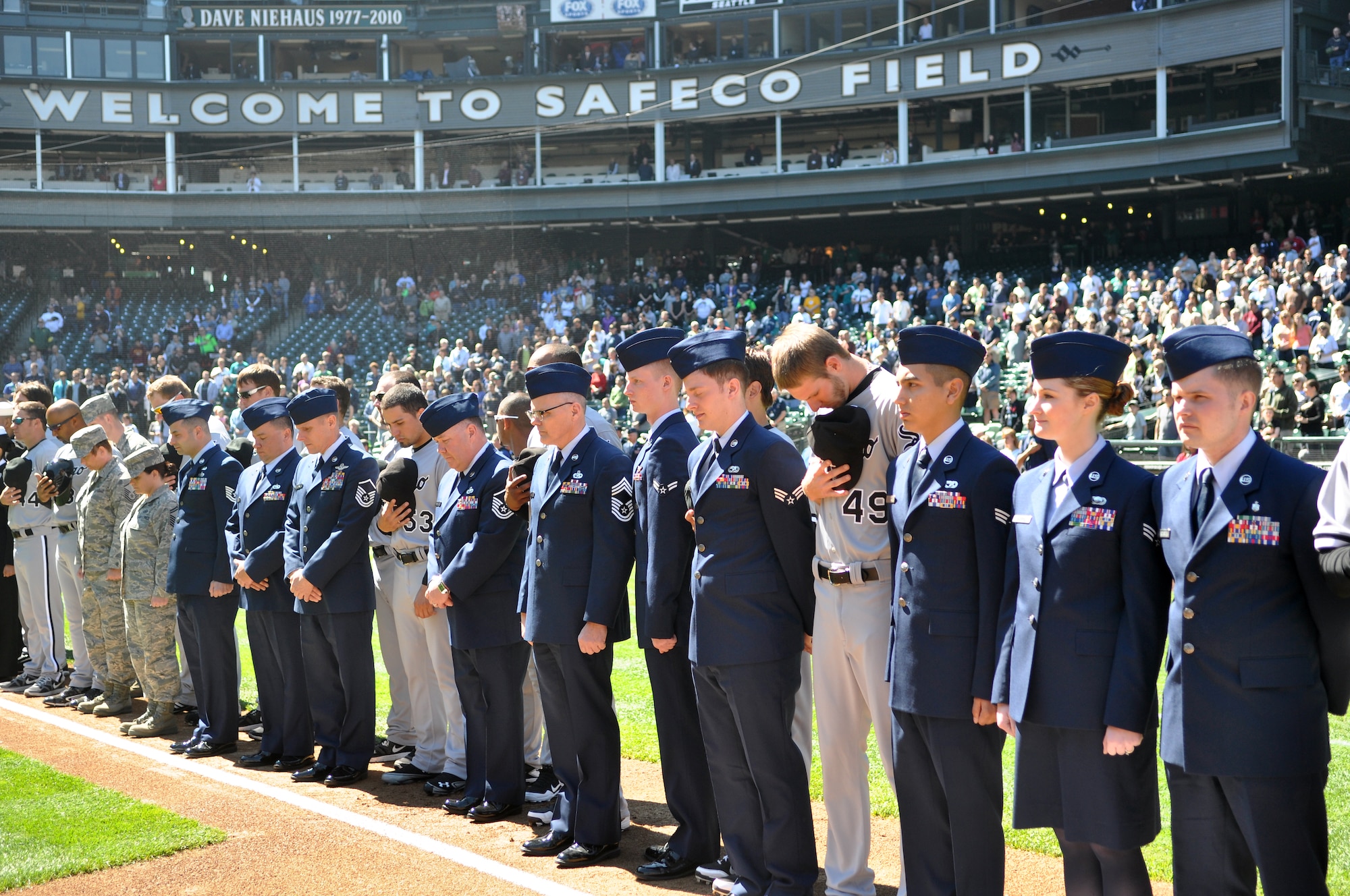 62nd Airlift Wing Airmen and other military representatives stand beside Chicago White Sox players while Taps was played during opening ceremonies at the 11th annual Seattle Mariners Armed Forces Day April 21, 2012, at Safeco Field in Seattle, Wash. (U.S. Air Force photo/Senior Airman Leah Young)
