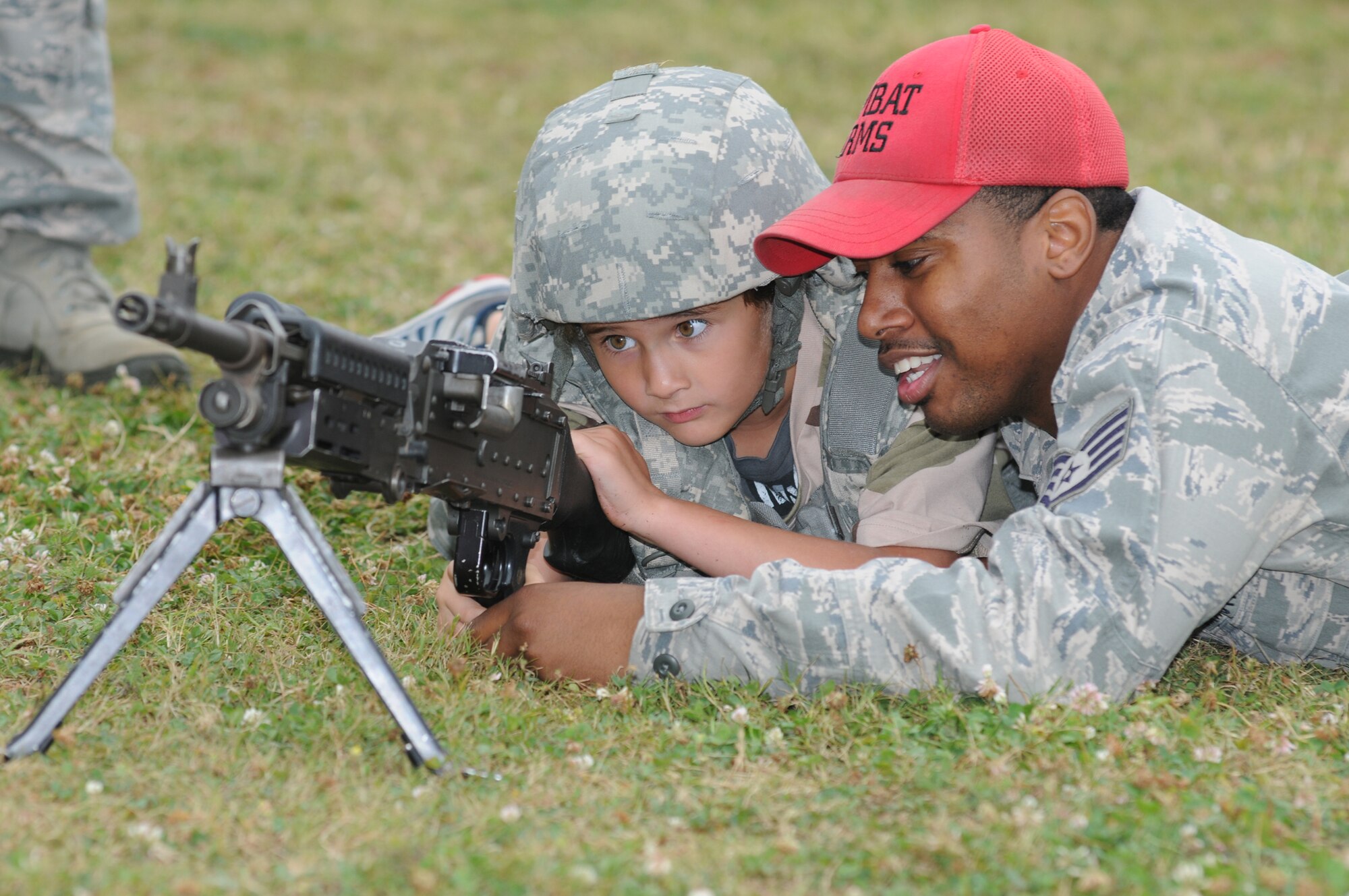 Six-year-old Eathen Bunce, son of Master Sgt. James and Tech. Sgt. Caroline Bunce, 81st Dental Squadron, gets close and personal with an M240 Bravo weapon with the assistance of Staff Sgt. Richard Gibbs, 81st Security Forces Squadron, during Operation Hero April 21, 2012, at Keesler Air Force Base, Miss.  Operation Hero takes place twice a year.  The event was designed to help children better understand what a deployment is and what happens when their parents deploy.  (U.S. Air Force photo by Kemberly Groue)