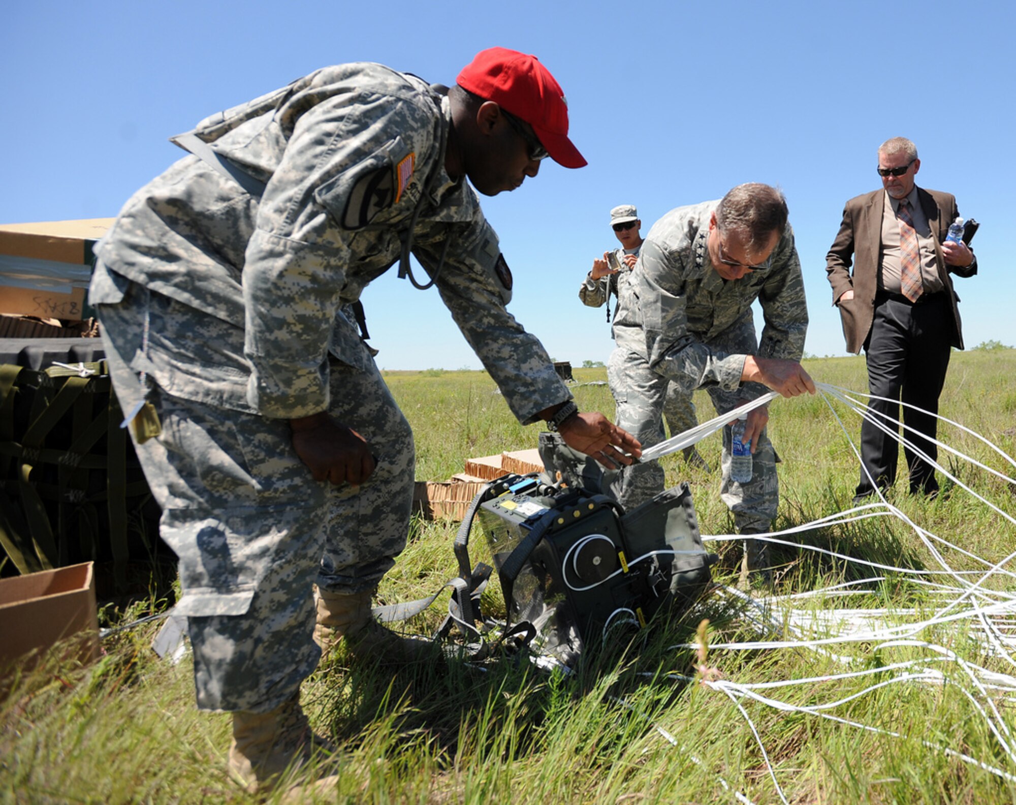 General William M. Fraser III, commander of U.S. Transportation Command, and Staff Sgt. Cabe Scotland, 294th Quartermaster Company, National Guard, inspect the JPADS's Automatic Guidance Unit, which ensures a precise drop location, during a training exercise Tuesday, April 24, at the Antelope Drop Zone at Fort Hood. The joint exercise was conducted by the Air Force's 317th Airlift Group, responsible for flying the C-130s, and the National Guard's 294th Quartermaster Company, responsible for packing, rigging and loading the bundles onto the aircraft. (Photo by Daniel Cernero, III Corps and Fort Hood Public Affairs)