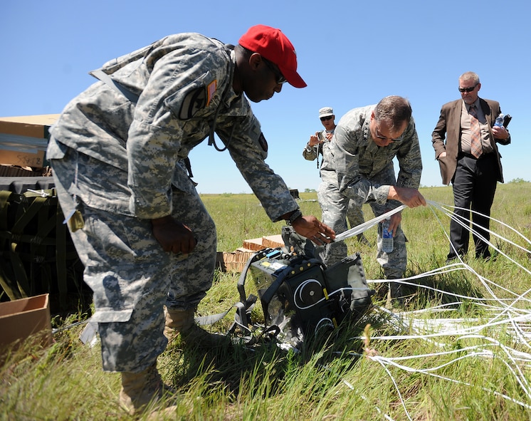 U.S. Air Force Gen. William M. Fraser III, commander of U.S. Transportation Command, and Staff Sgt. Cabe Scotland, 294th Quartermaster Company, National Guard, inspect the JPADS's Automatic Guidance Unit, which ensures a precise drop location, during a training exercise, April 24, at the Antelope Drop Zone at Fort Hood. The joint exercise was conducted by the Air Force's 317th Airlift Group, responsible for flying the C-130s, and the National Guard's 294th Quartermaster Company, responsible for packing, rigging and loading the bundles onto the aircraft. (Photo by Daniel Cernero, III Corps and Fort Hood Public Affairs) 

